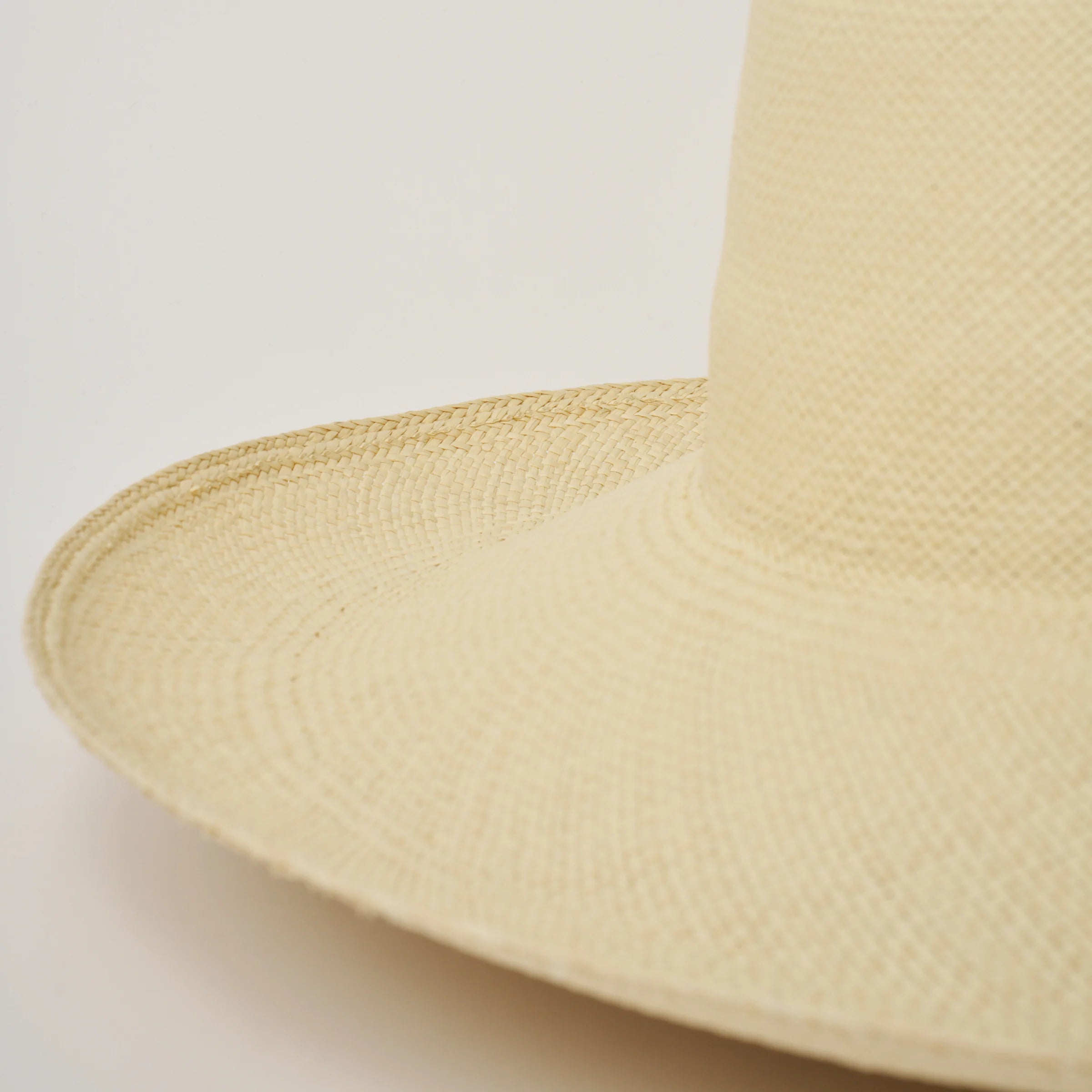 Studio image of the Alba Natural coloured Panama Hat closeup shown from the side, showing the brim curve.