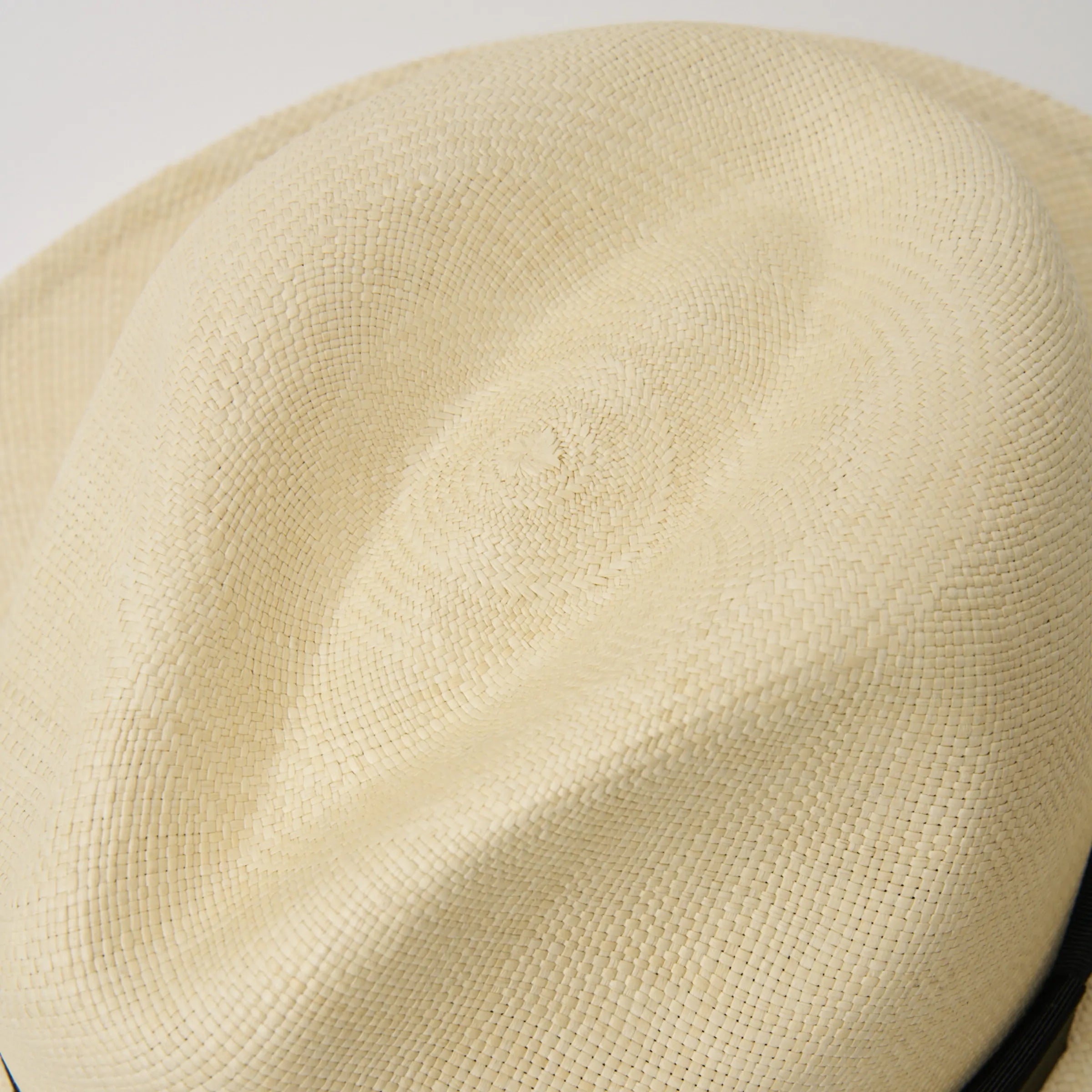 Studio image closeup of the crown shape and weave on the Camilo Classic Fino Natural coloured Panama Hat with Black trim.