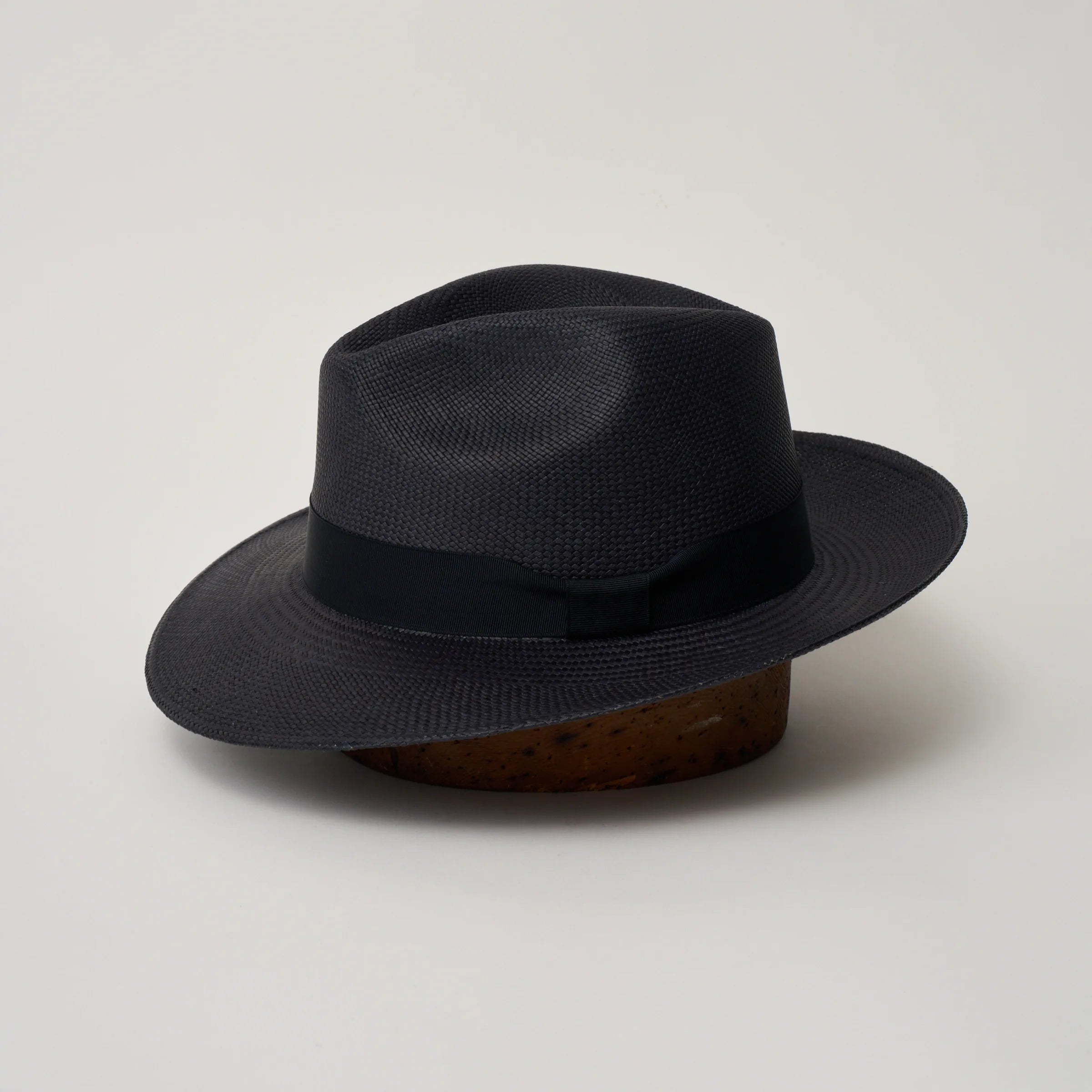Studio image of the Camilo Classic Navy coloured Panama Hat with Marine trim shown from the side, showing the brim sweep and ribbon finish.