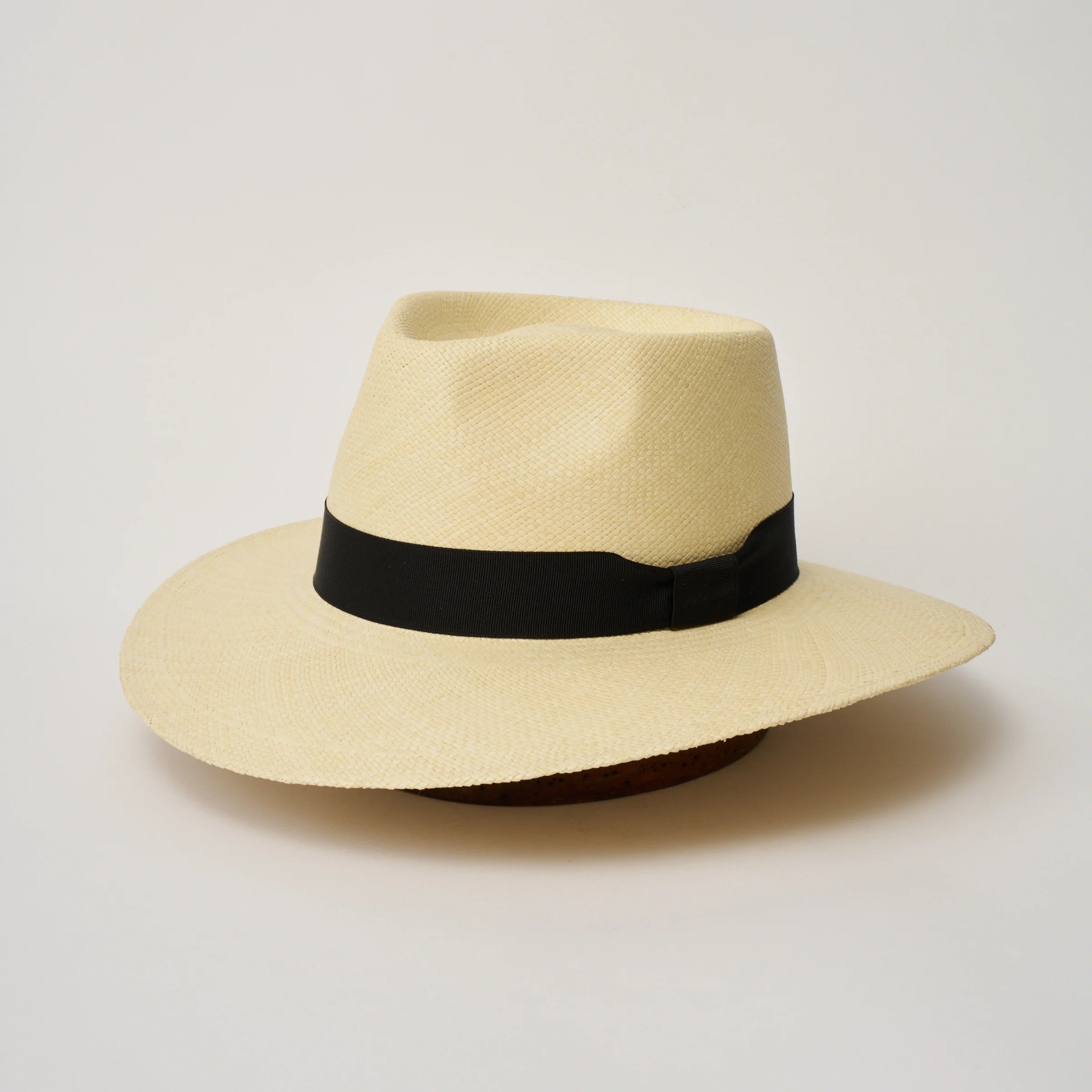 Studio image of the Camilo Country Natural coloured Panama Hat with Black trim, angled showing the crown shape, front crease and ribbon details.