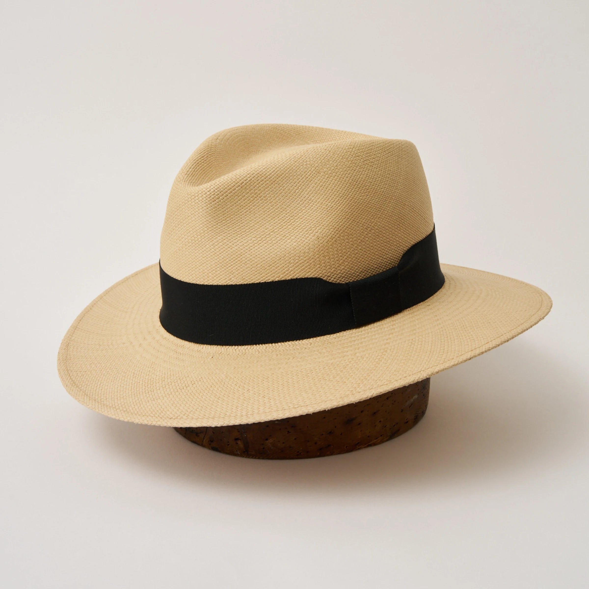 Studio image of the Camilo Executive Fino Sand coloured Panama Hat with Black trim, angled showing the crown shape, front crease and ribbon details.