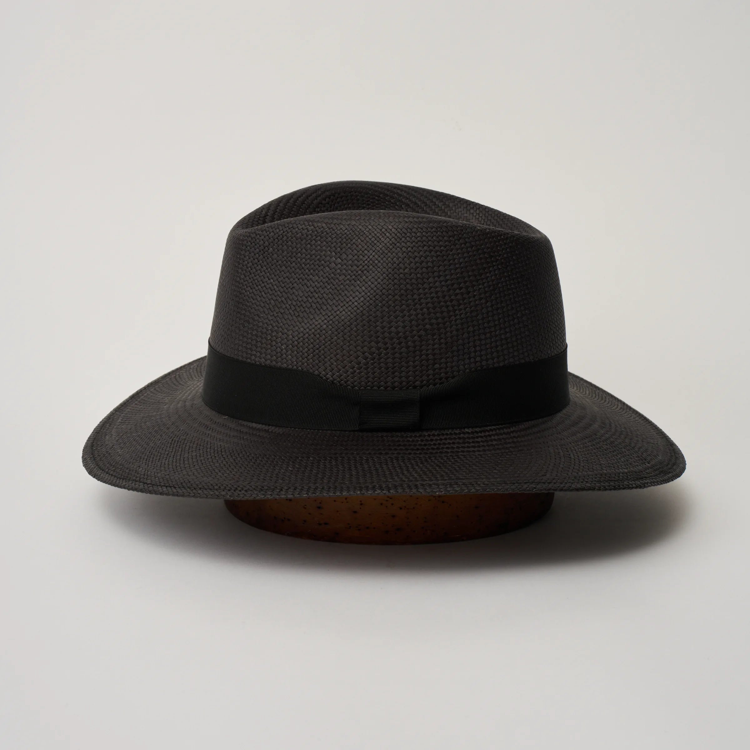 Studio image of the Camilo Executive
Black coloured Panama Hat with Black trim shown from the side, showing the brim shape and ribbon finish.