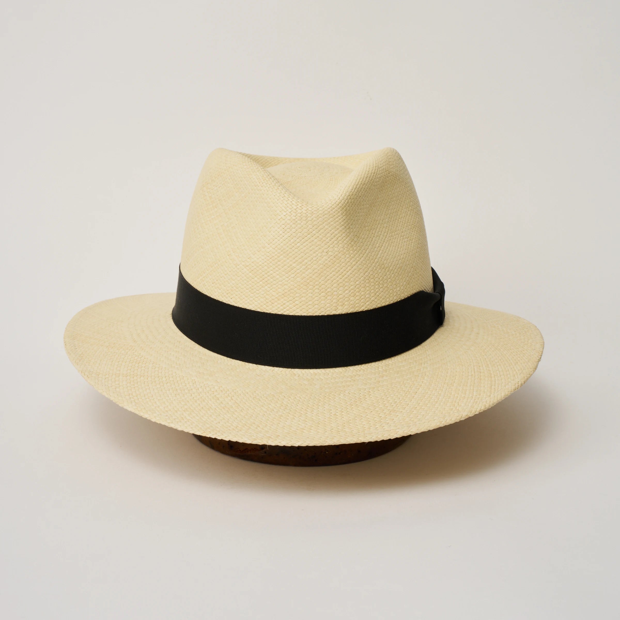Studio image of the Camilo Executive Natural coloured Panama Hat with Black trim taken from the front, showing pinch.