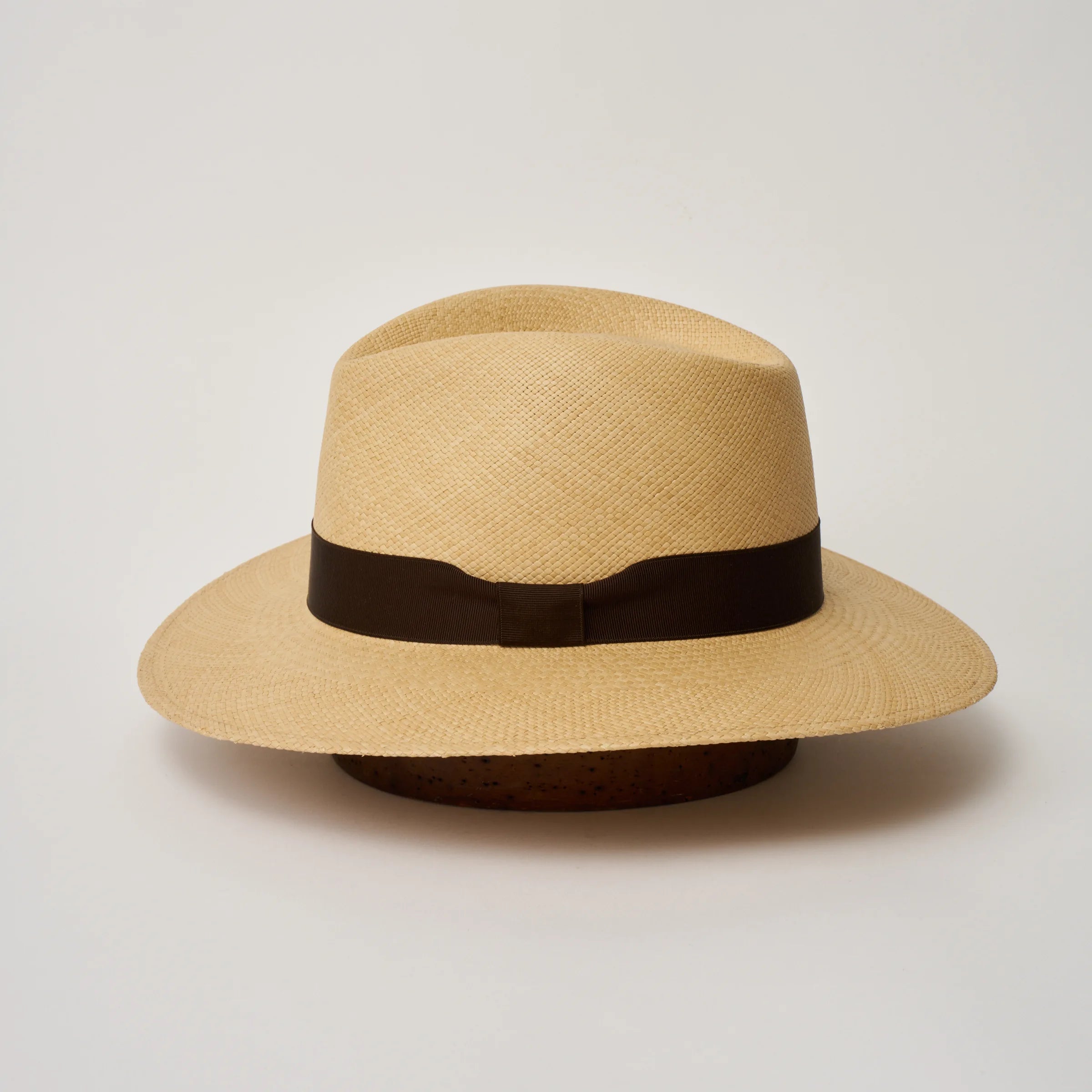 Studio image of the Camilo Executive
Sand coloured Panama Hat with Caffe trim shown from the side, showing the brim shape and ribbon finish.