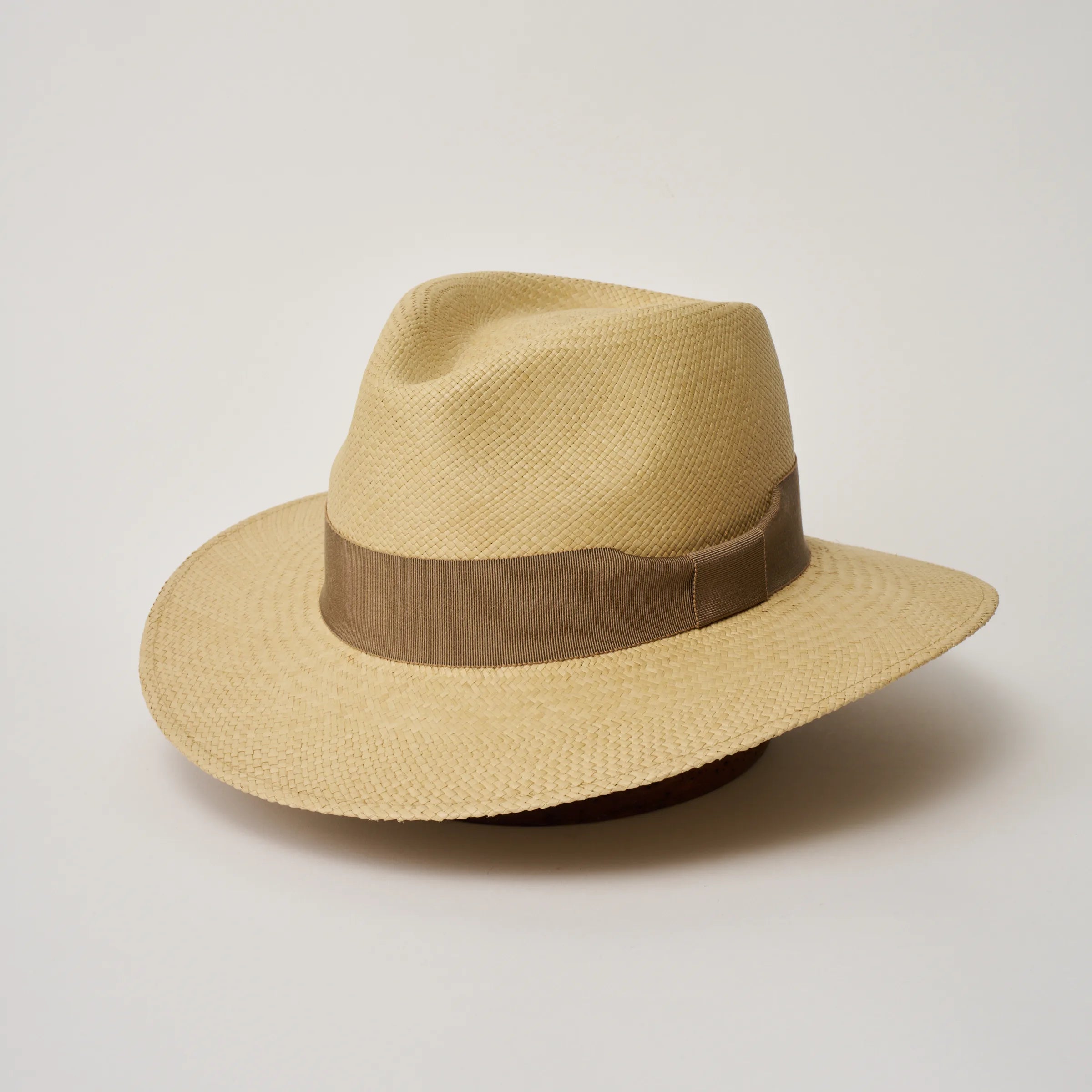 Studio image of the Camilo Executive Sand coloured Panama Hat with Oat trim, angled showing the crown shape, front crease and ribbon details.