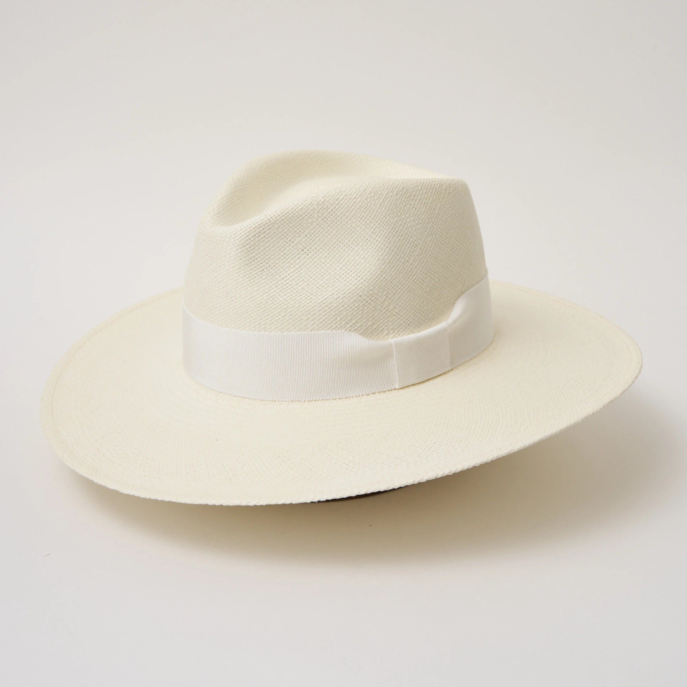 Studio image, angled view of the Camilo Oro Cream coloured Panama Hat with White trim, showing the overall hat shape.