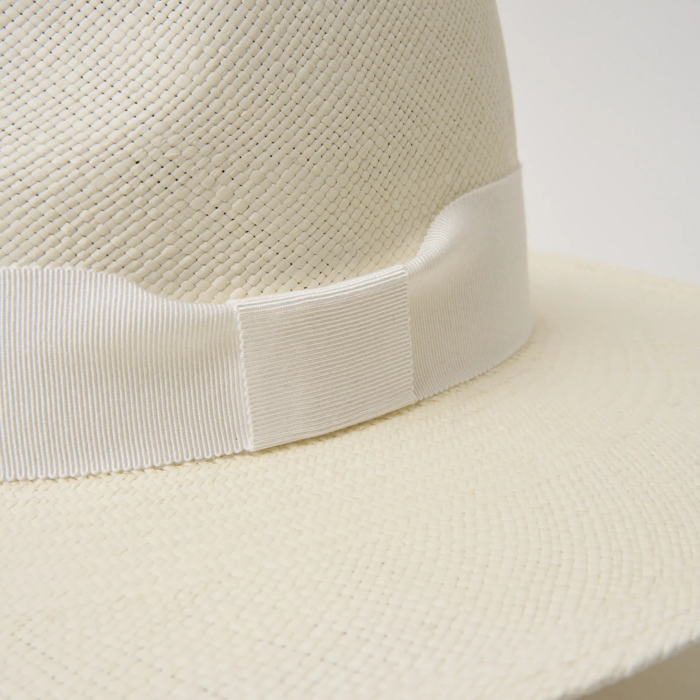 Studio closeup image of the white ribbon trim detail on the cream coloured Camilo Oro Panama hat.