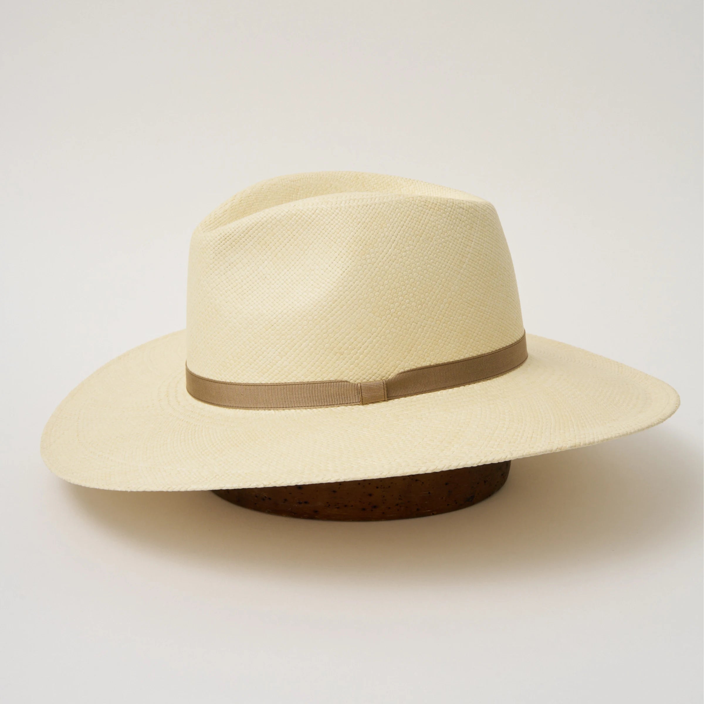Studio image of the Camilo Oro Natural coloured Panama Hat with Taupe trim taken from the side, showing brim and ribbon finish.