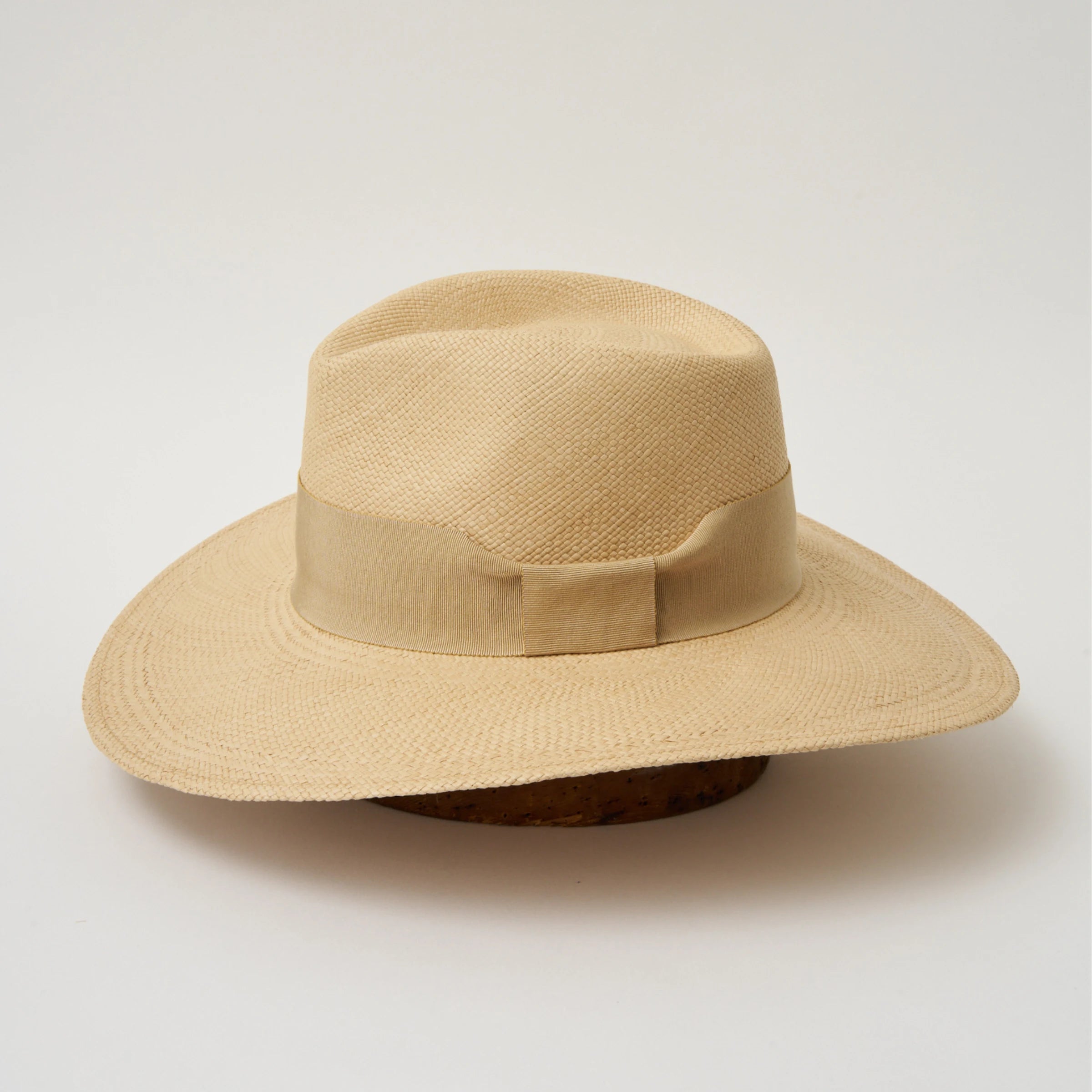 Studio image of the Camilo Oro Sand coloured Panama Hat with Camel trim taken from the side, showing brim and ribbon finish.