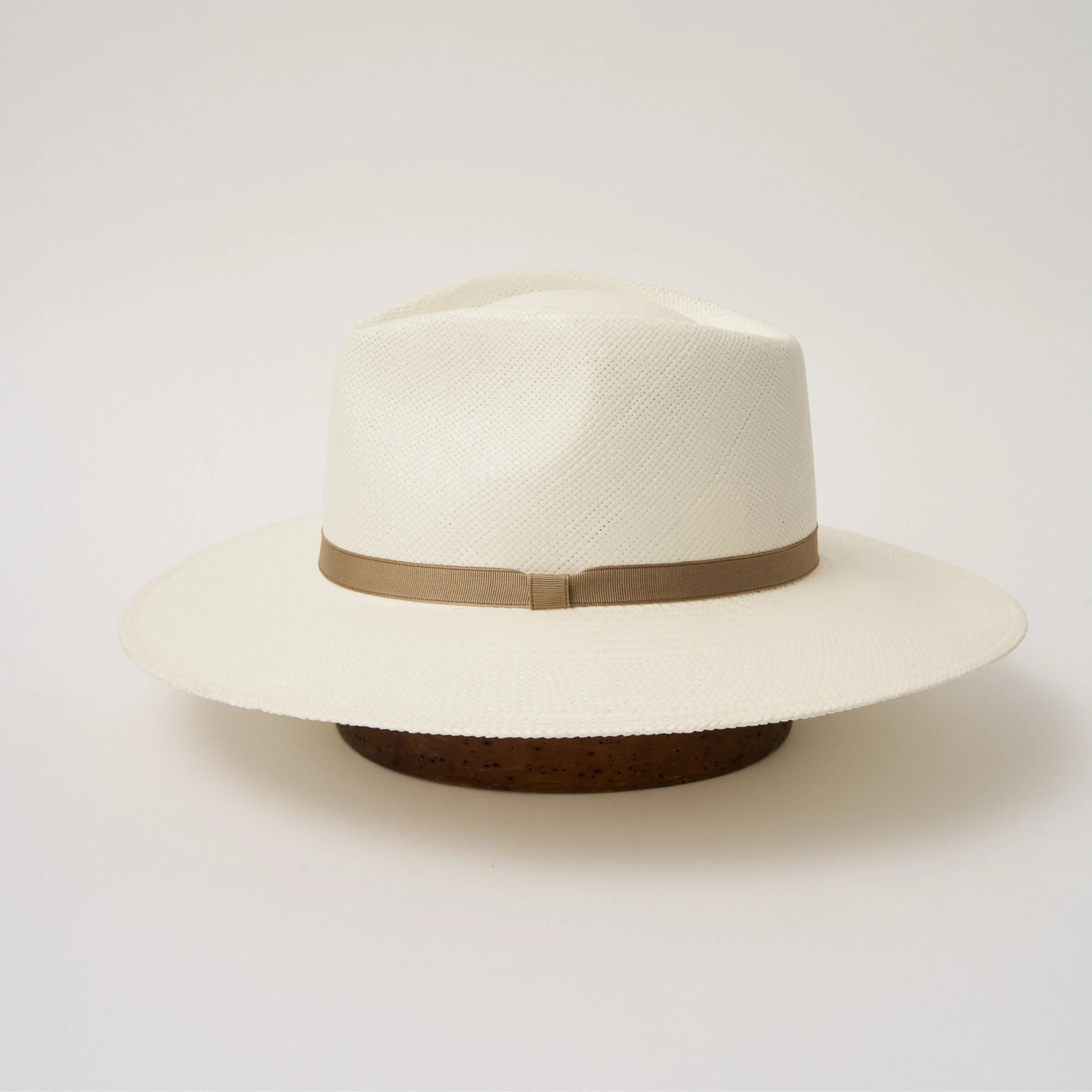 Studio image of the Camilo Vita Cream coloured Panama Hat with Taupe trim taken from the side, showing brim and ribbon finish.