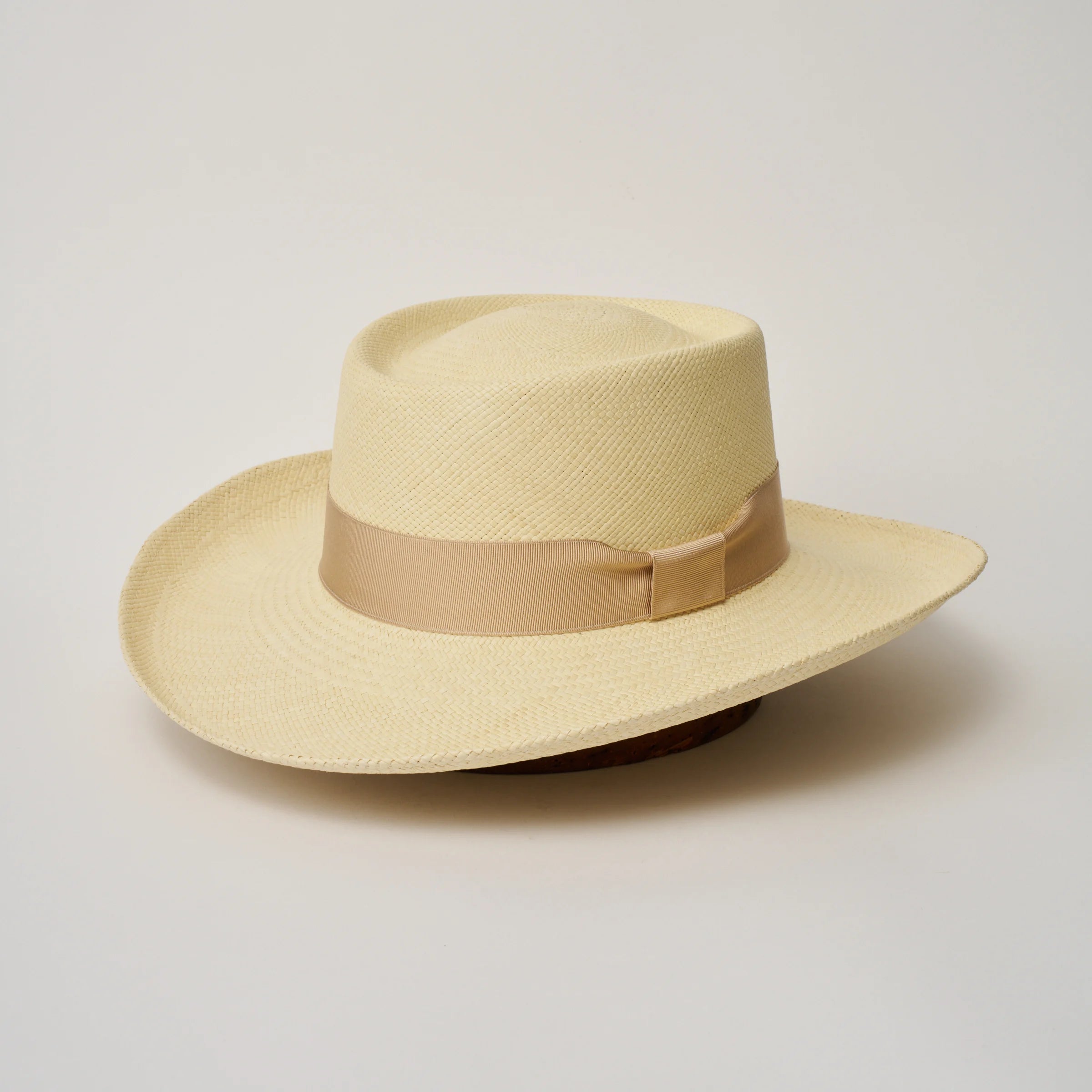 Studio image of the Camilo Gambler Natural coloured Panama Hat with Bone trim, angled showing the crown shape, front crease and ribbon details.