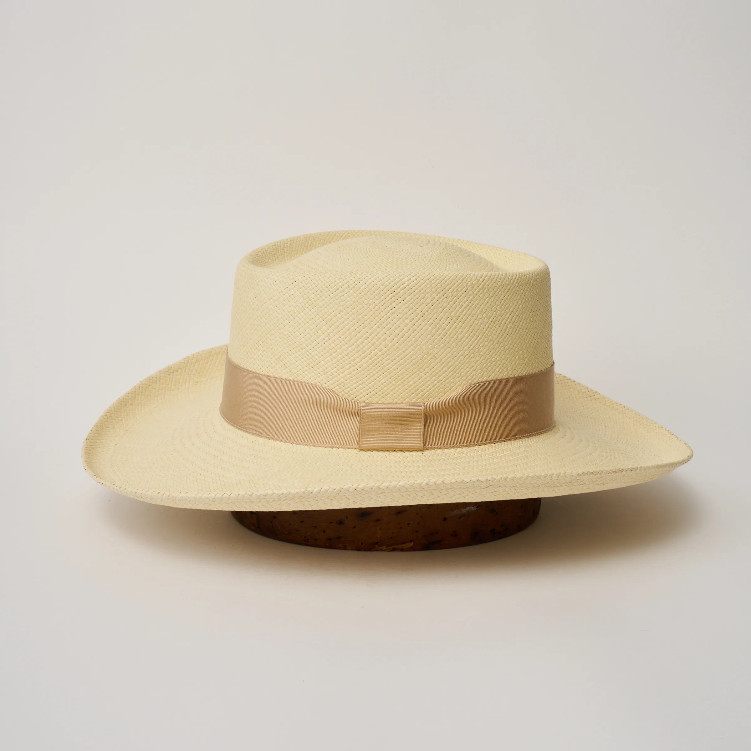 Studio image of the Camilo Gambler
Natural coloured Panama Hat with Bone trim shown from the side, showing the brim shape and ribbon finish.