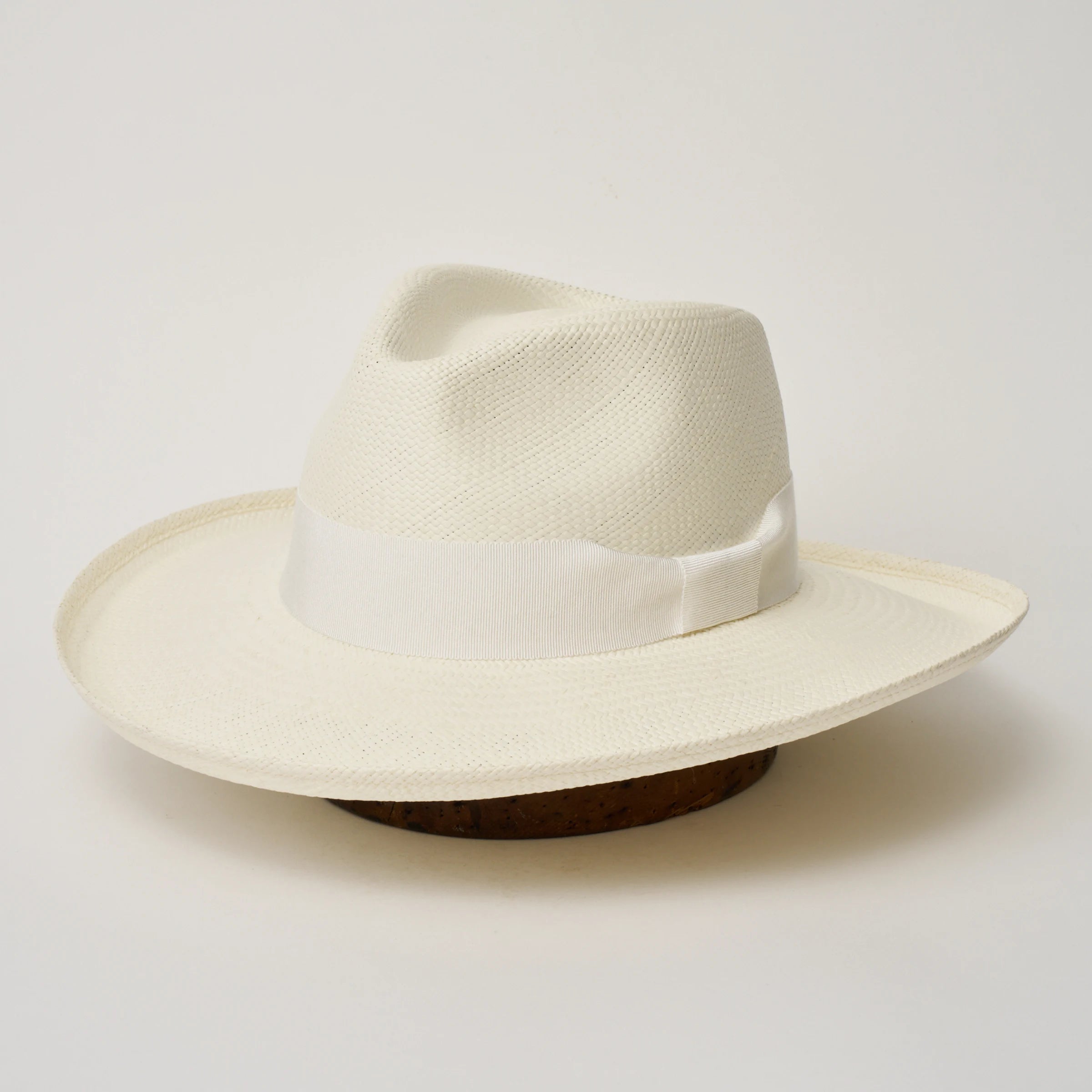 Studio image of the Camilo Grand Planter Cream coloured Panama Hat with White trim, angled showing the crown shape, front crease and ribbon details.