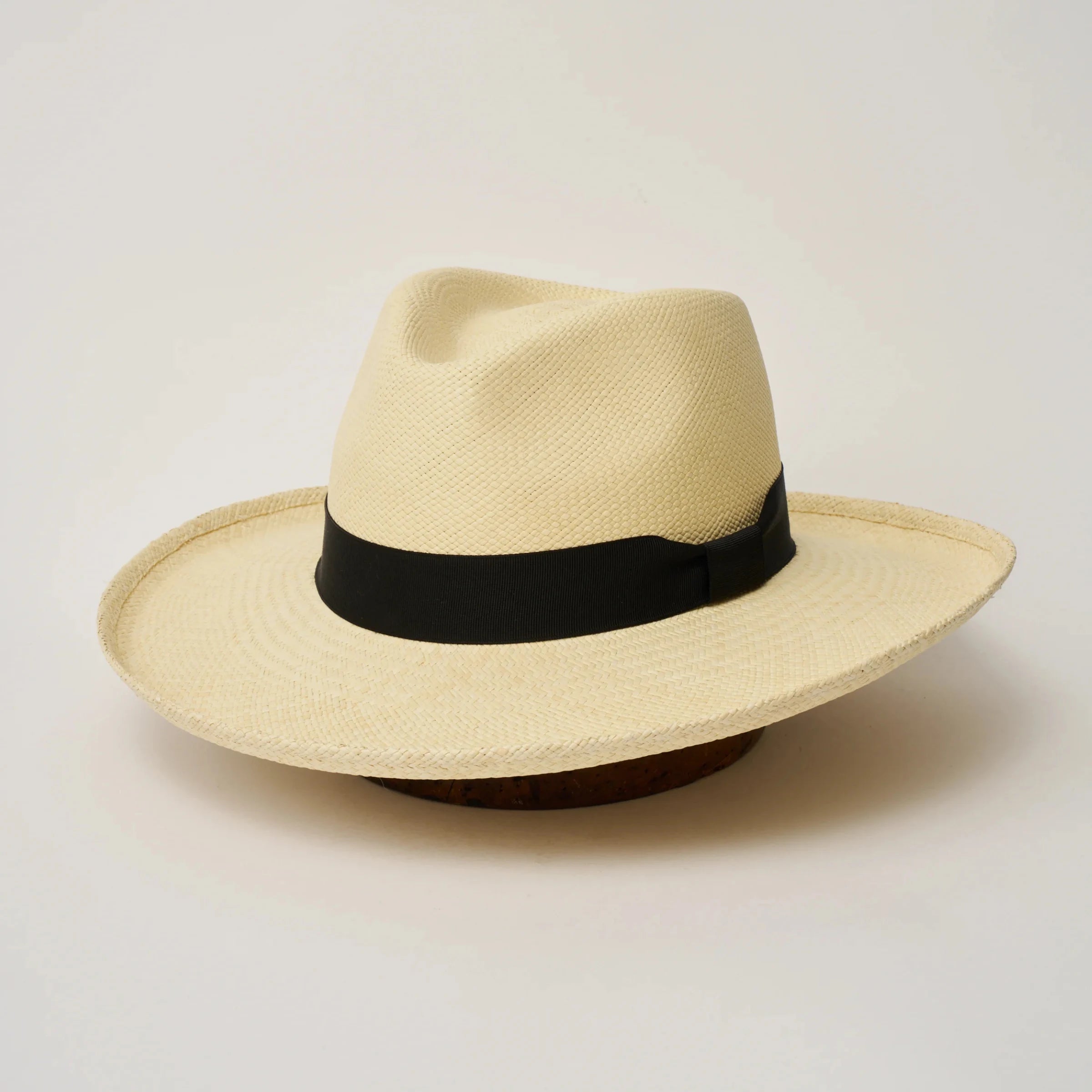Studio image of the Camilo Grand Planter Natural coloured Panama Hat with Black trim, angled showing the crown shape, front crease and ribbon details.