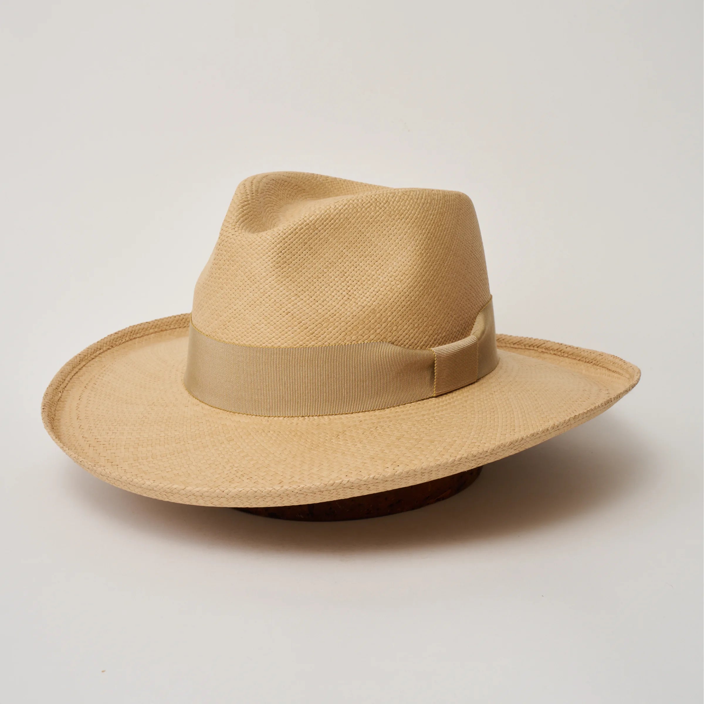 Studio image of the Camilo Grand Planter Sand coloured Panama Hat with Camel trim, angled showing the crown shape, front crease and ribbon details.