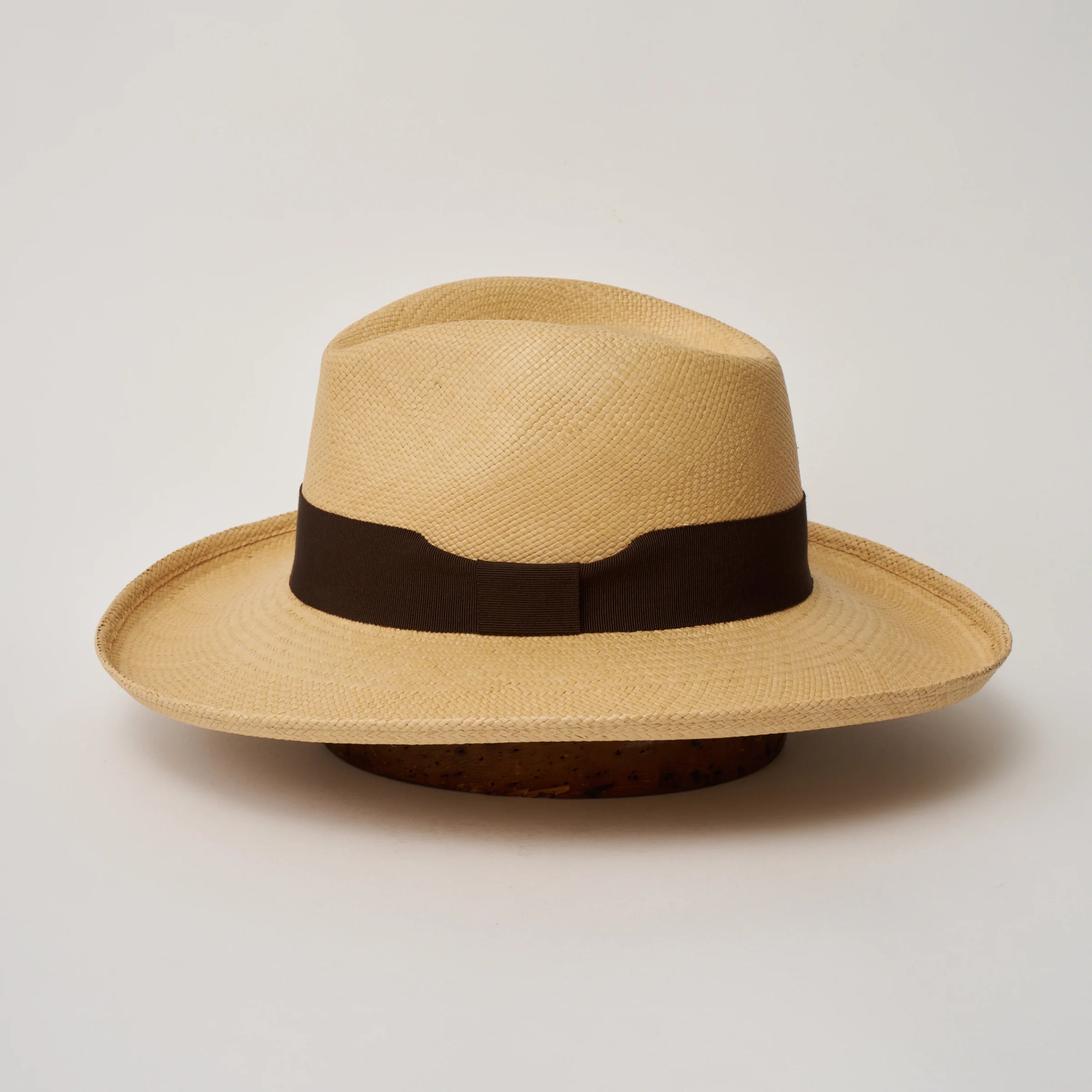 Studio image of the Camilo Grand Planter
Sand coloured Panama Hat with Chocolate trim shown from the side, showing the brim shape and ribbon finish.