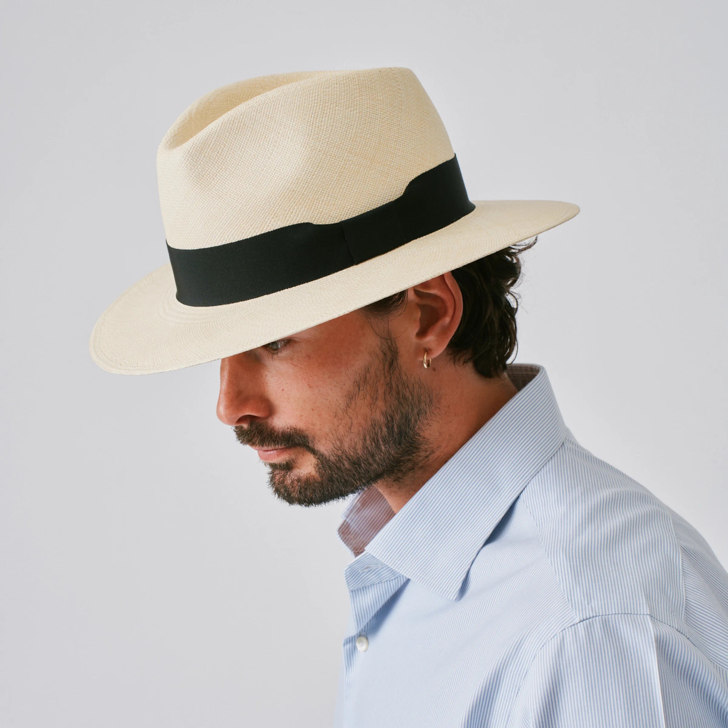 Man wearing a Executive Fino Natural / Black Panama hat against a plain background.