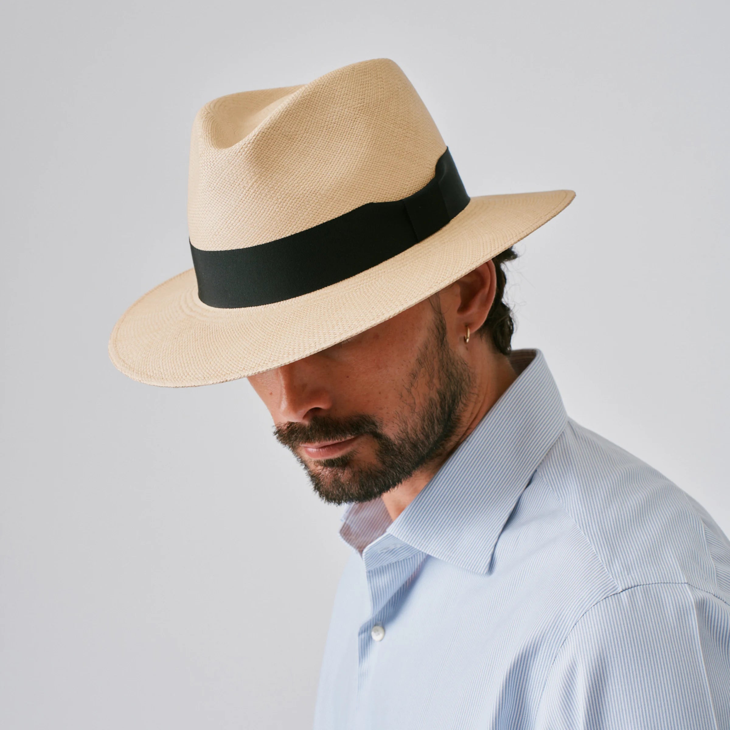 Man wearing a Executive Fino Sand / Black Panama hat against a plain background.