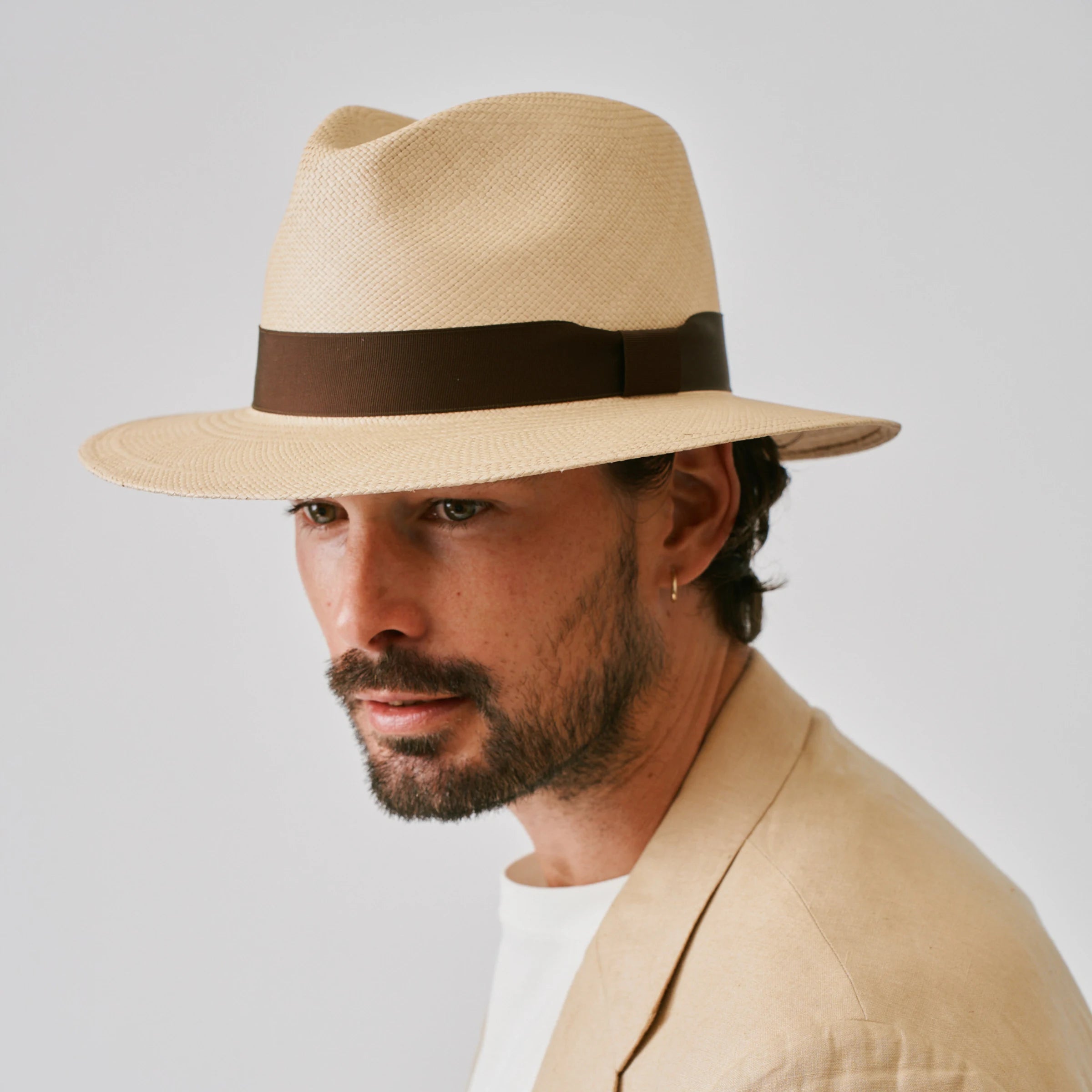 Man wearing a Executive Sand / Caffe Panama hat against a plain background.