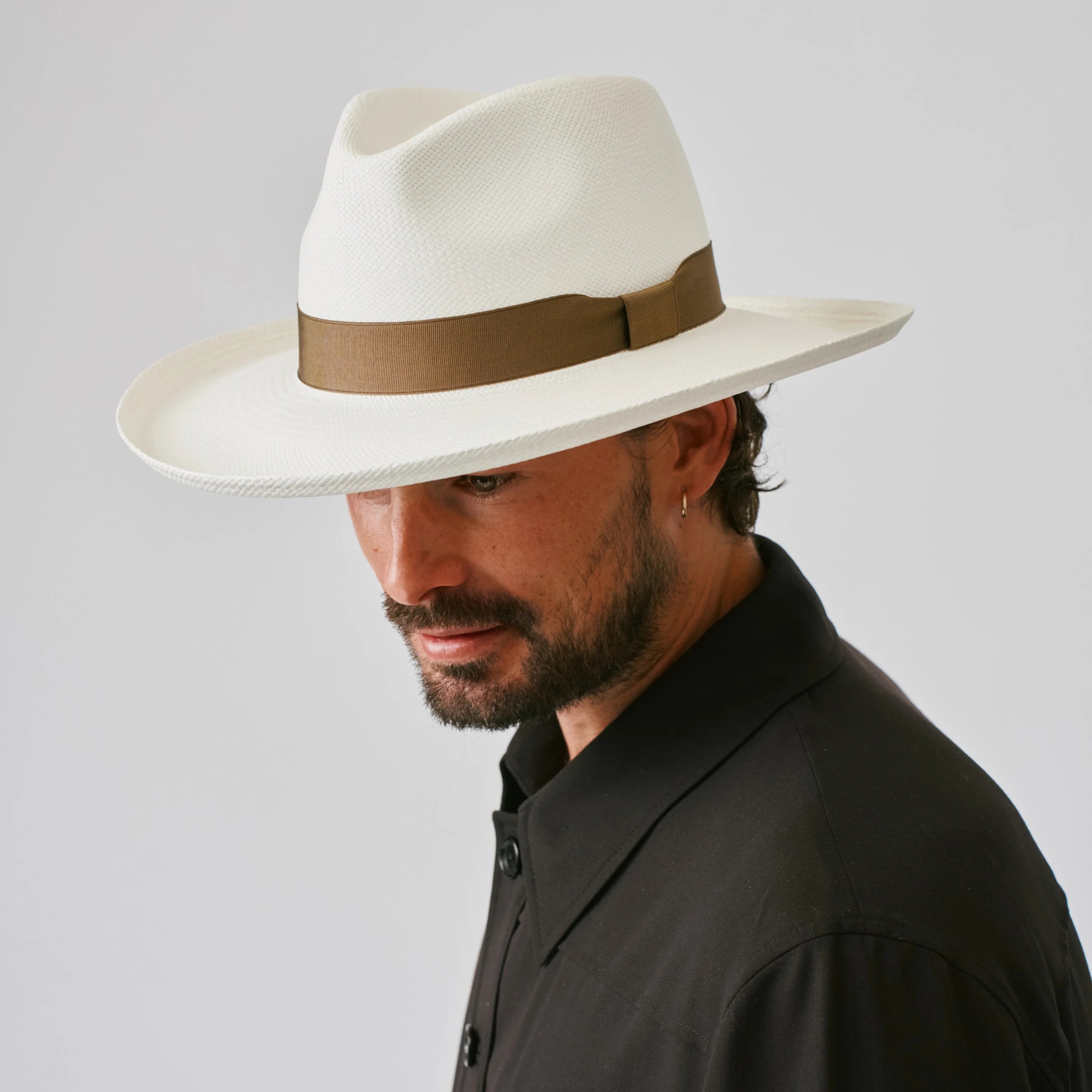 Man wearing a Grand Planter Cream / Fawn Panama hat against a plain background.