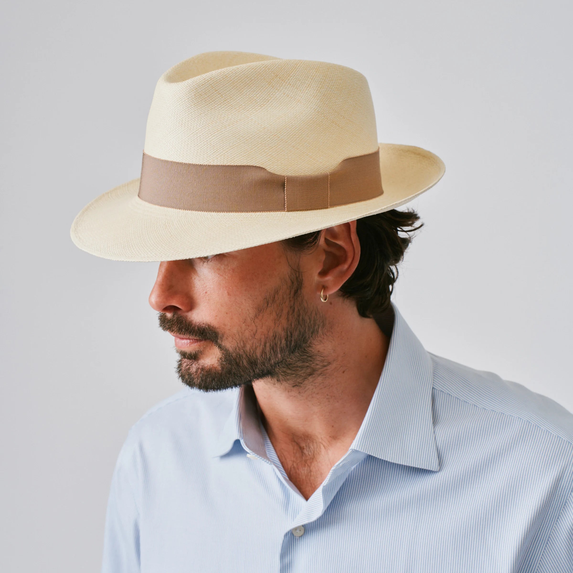 Man wearing a New Fedora Fino Natural / Oat Panama hat against a plain background.