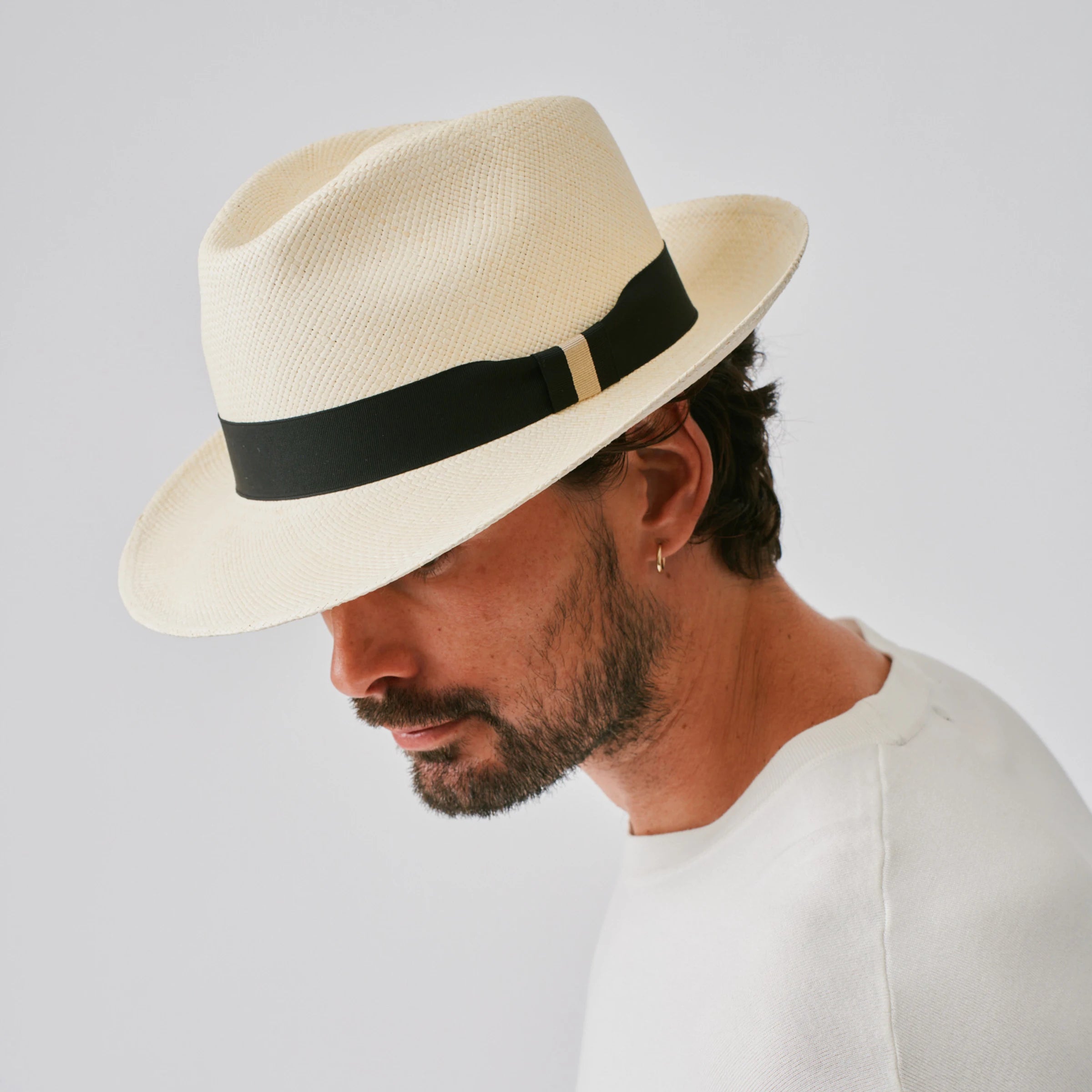 Man wearing a New Fedora Natural / Black Panama hat against a plain background.