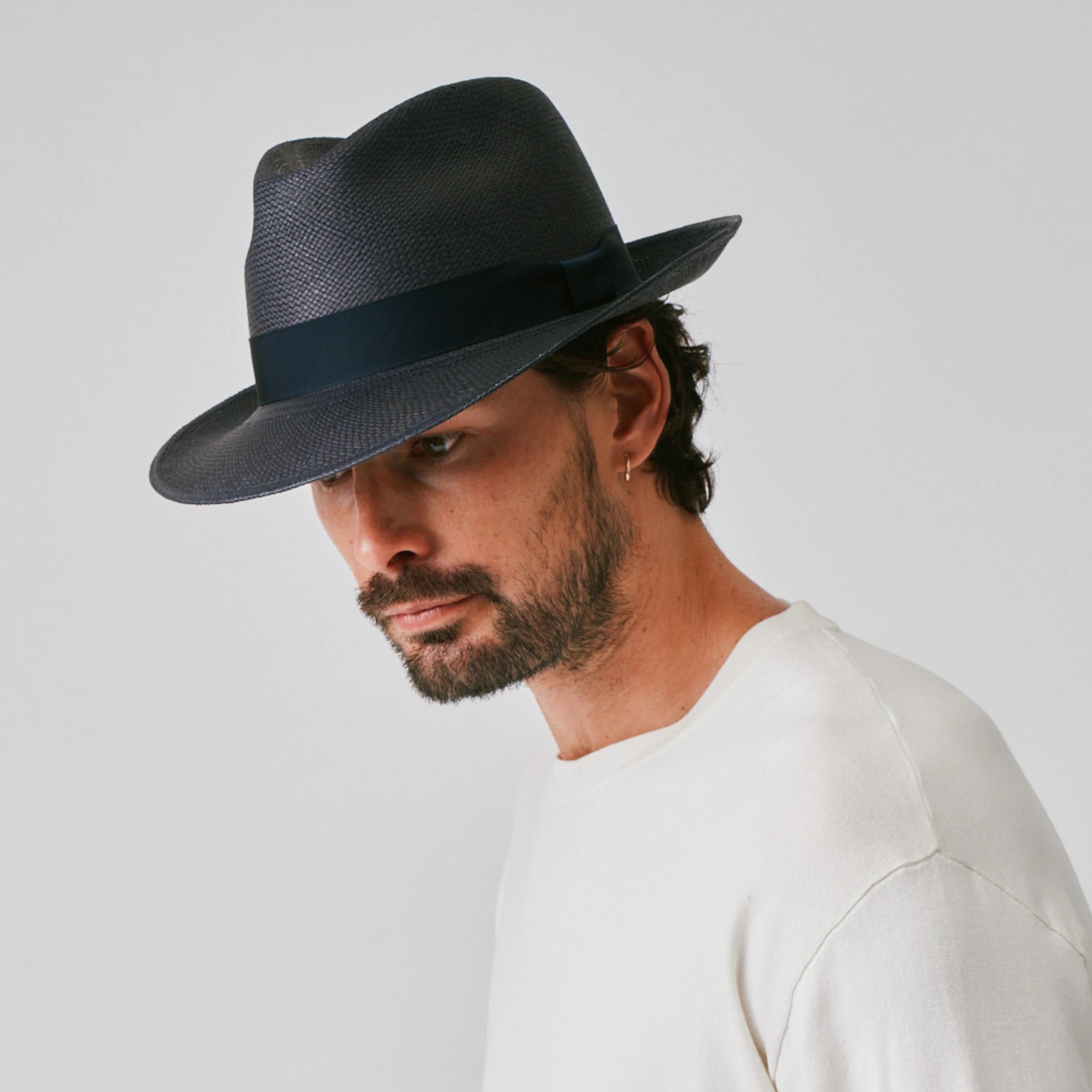 Man wearing a New Fedora Navy / Marine Panama hat against a plain background.