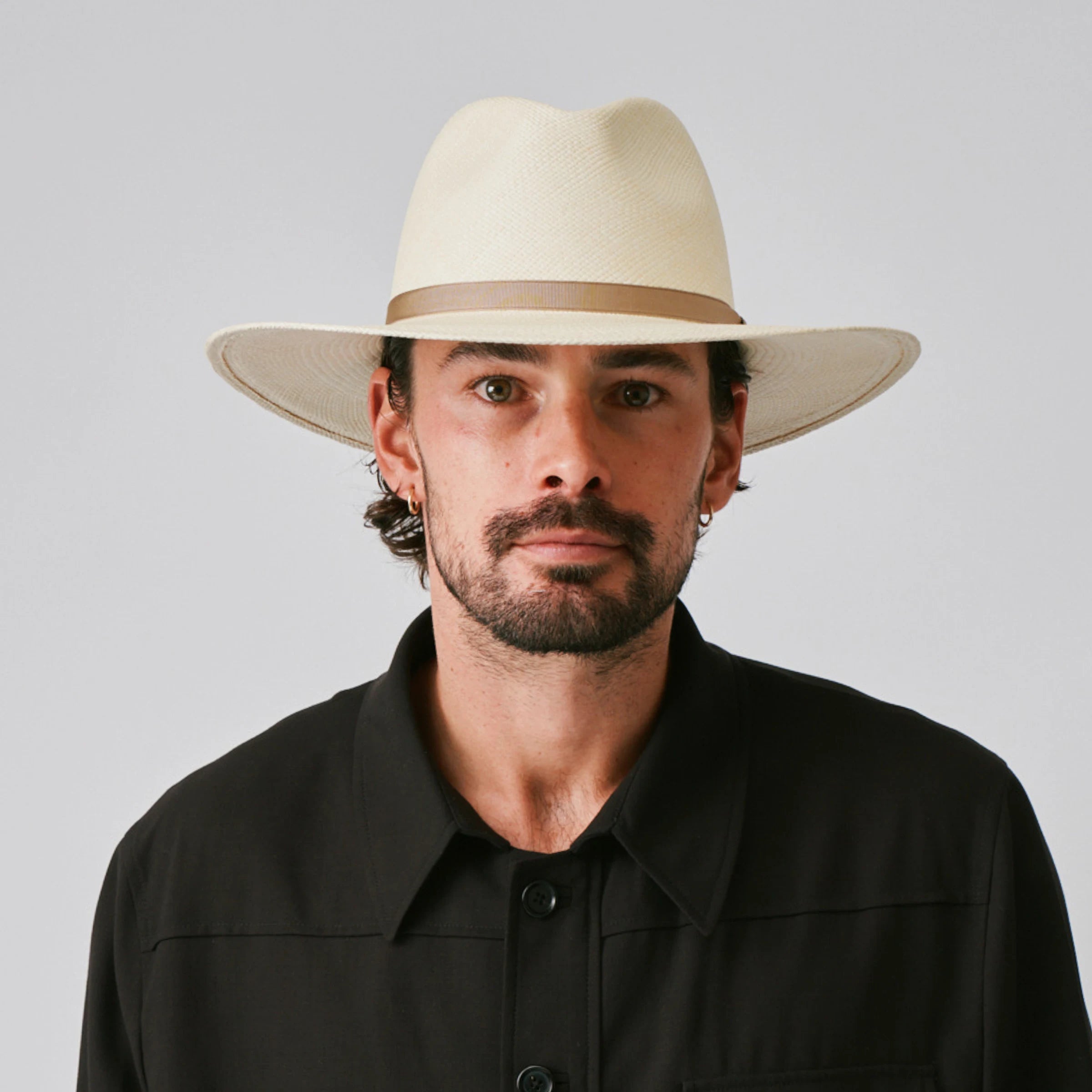 Man wearing a Oro Natural / Taupe Panama hat and black shirt against a plain background.
