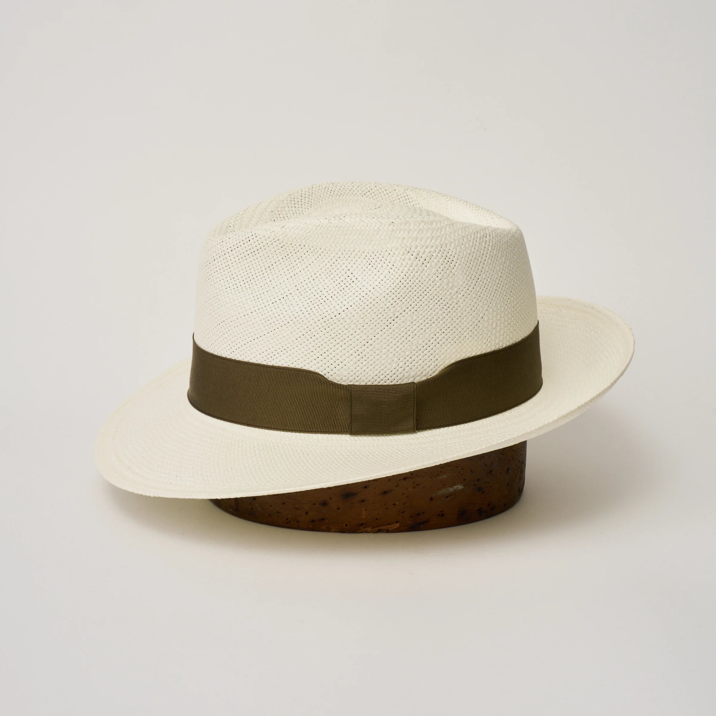 Studio image of the Camilo New Fedora Cream coloured Panama Hat with Fawn trim shown from the side, showing the brim shape and ribbon finish.
