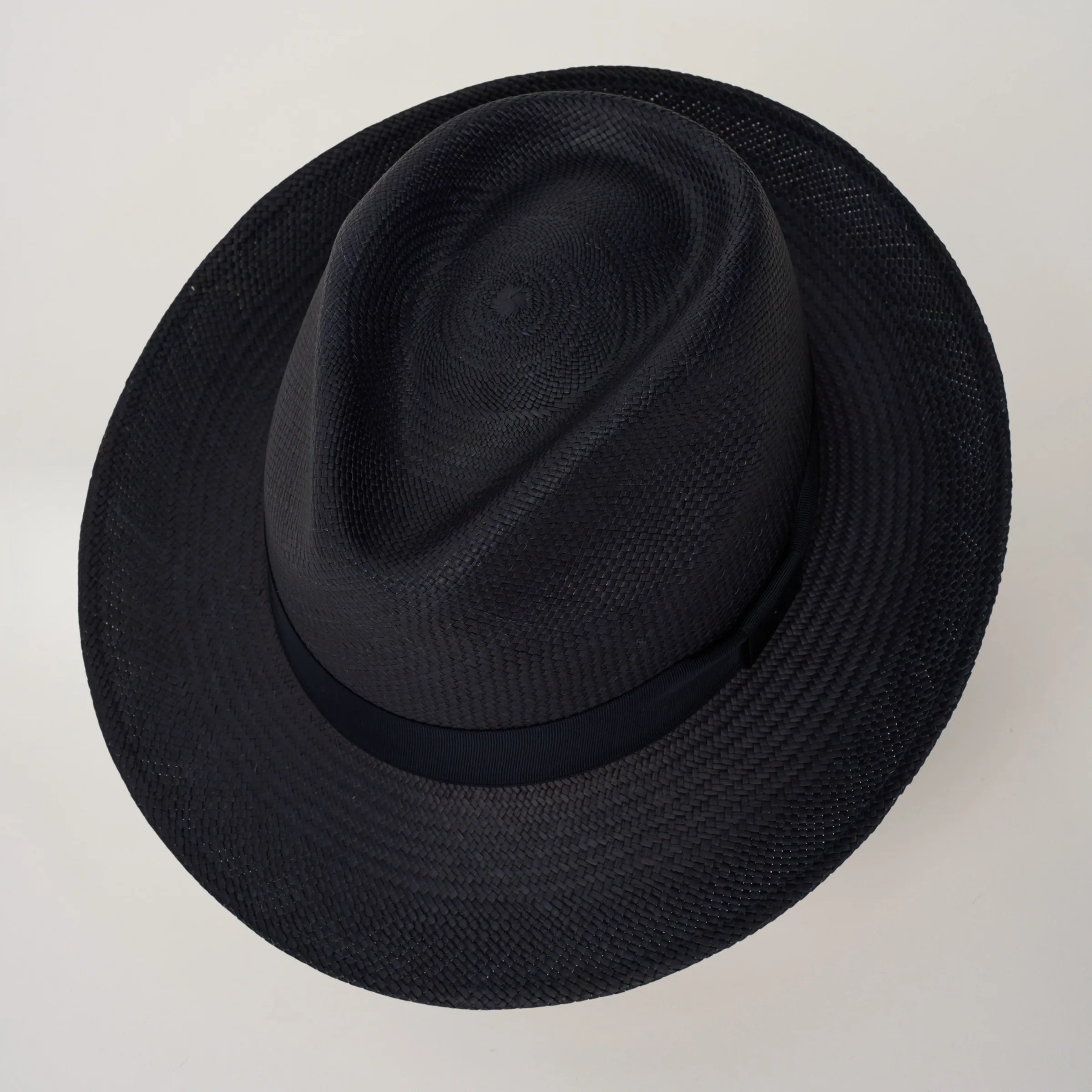 Studio image looking top-down, of the Camilo New Fedora Navy coloured Panama Hat with Marine trim, showing the crown shape and weave details.