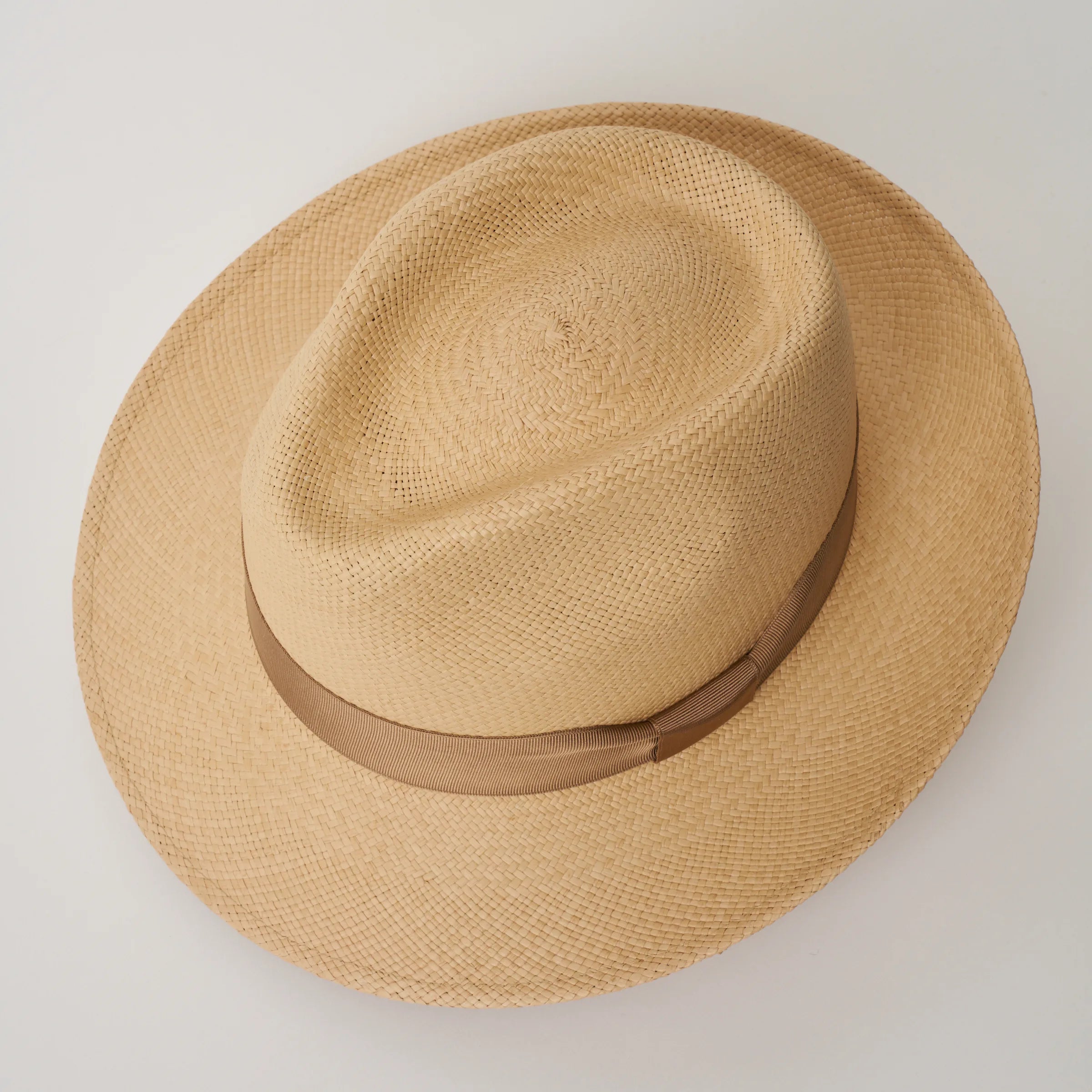 Studio image looking top-down, of the Camilo New Fedora Sand coloured Panama Hat with Tan trim, showing the crown shape and weave details.