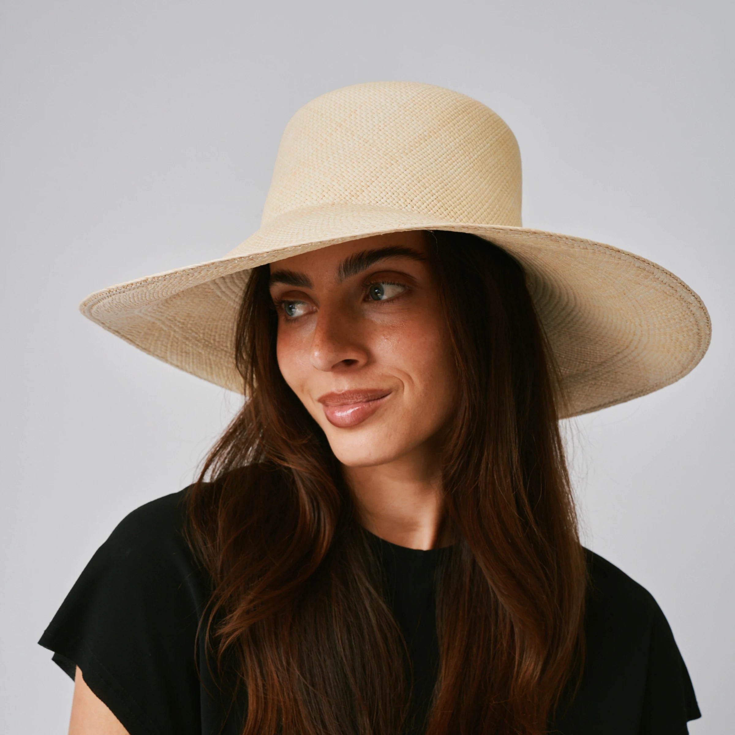 Woman wearing a Alba Natural Panama hat against a plain background.