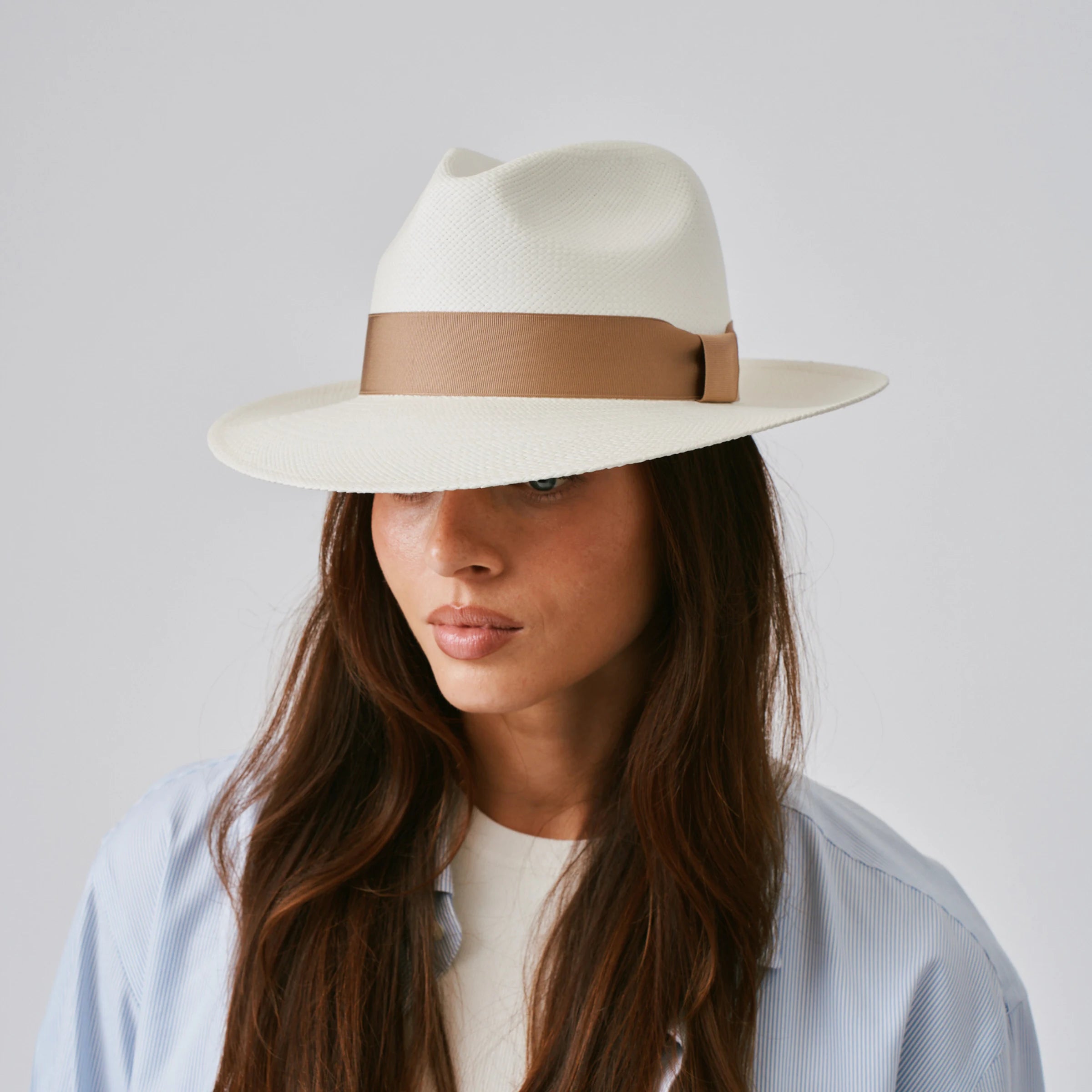 Woman wearing a Camilo Classic Cream / Tan Panama hat against a plain background.