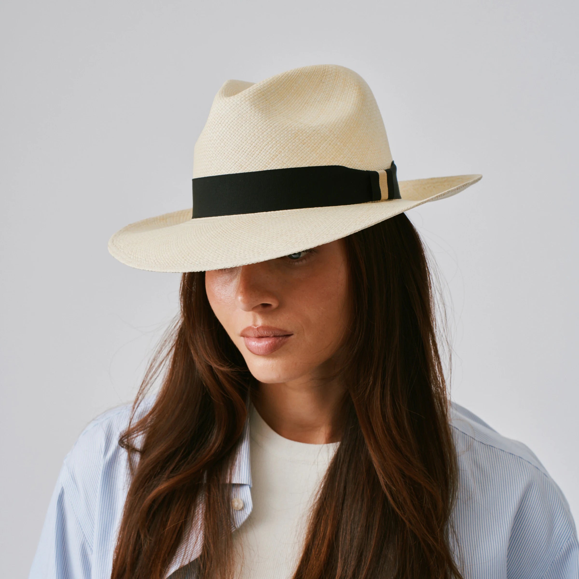 Woman wearing a Camilo Classic Natural / Black Panama hat against a plain background.