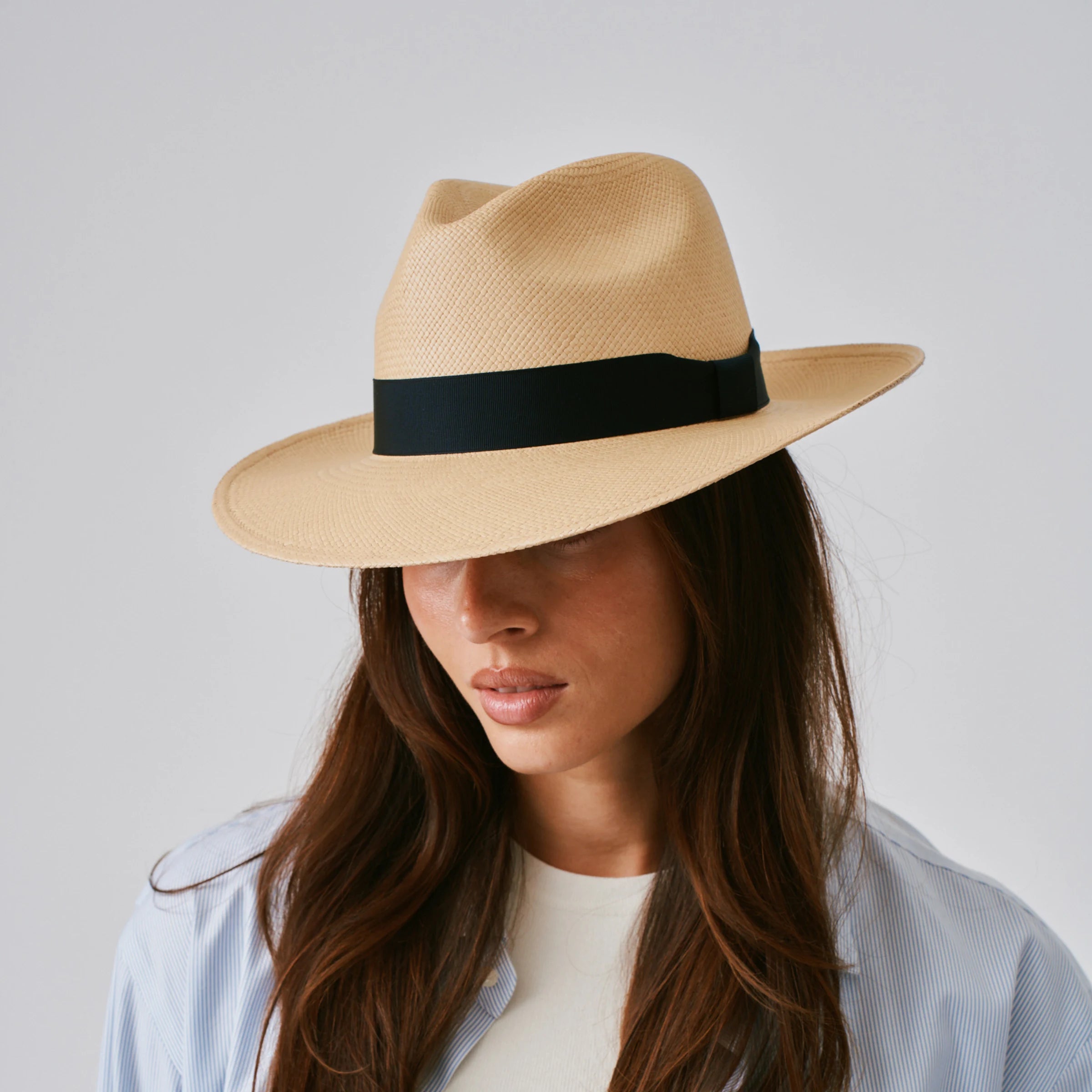 Woman wearing a Camilo Classic Sand / Marine Panama hat against a plain background.