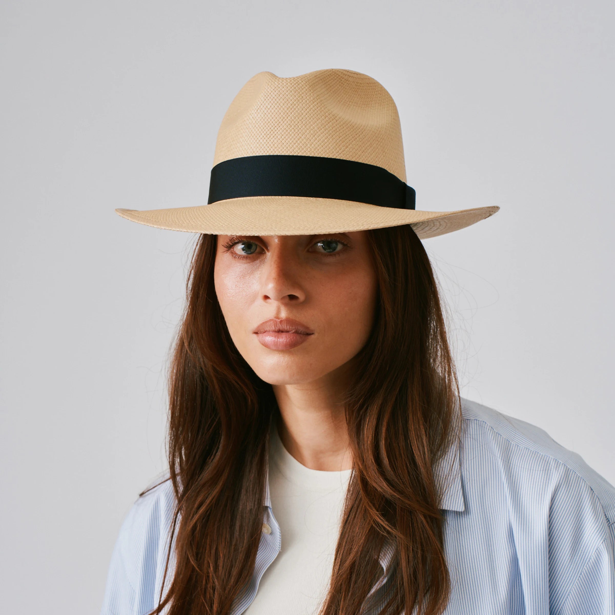 Woman wearing a Camilo Classic Sand / Marine Panama hat and a blue shirt against a plain background.