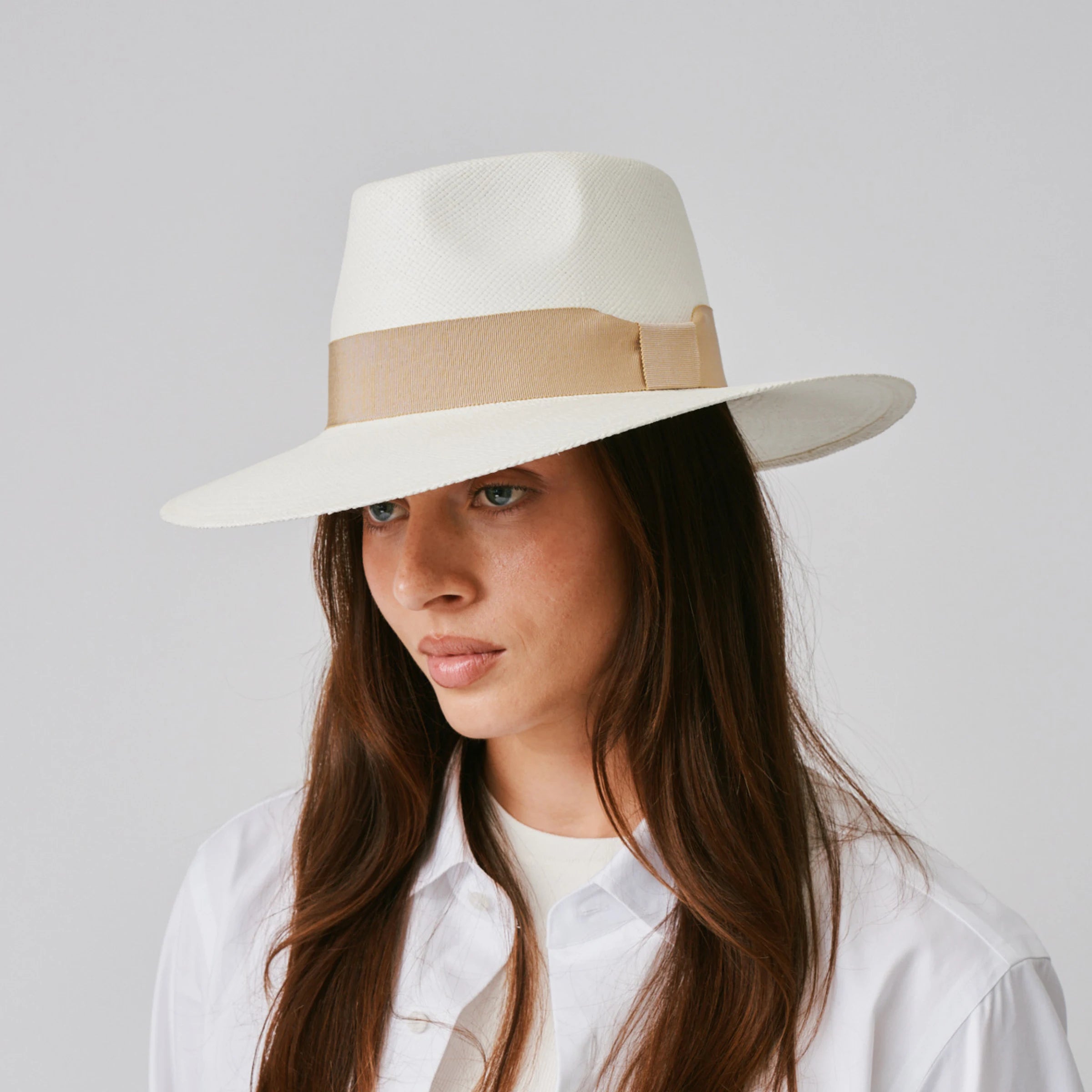 Woman wearing a Country Cream / Camel Panama hat against a plain background.