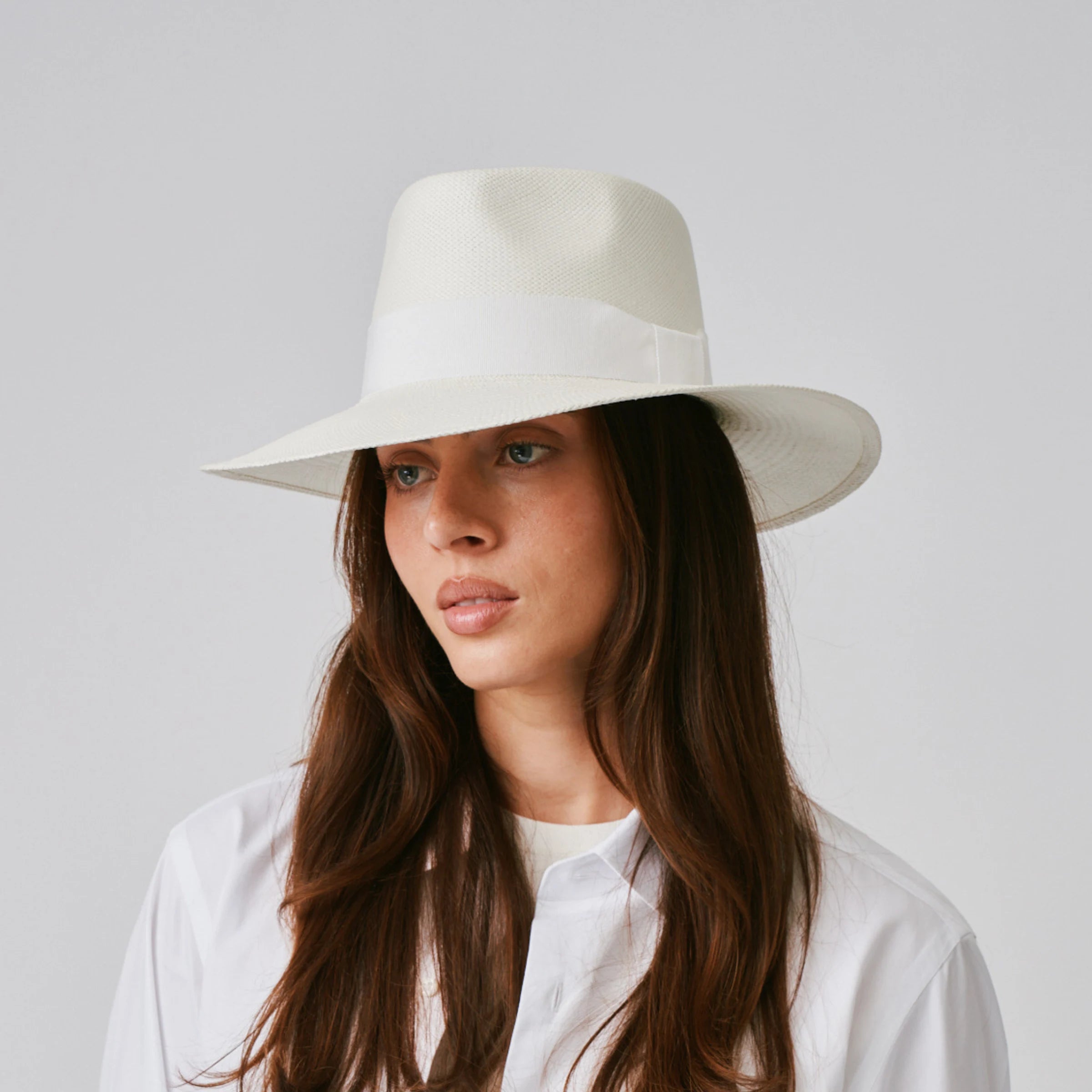 Woman wearing a Country Cream / White Panama hat against a plain background.