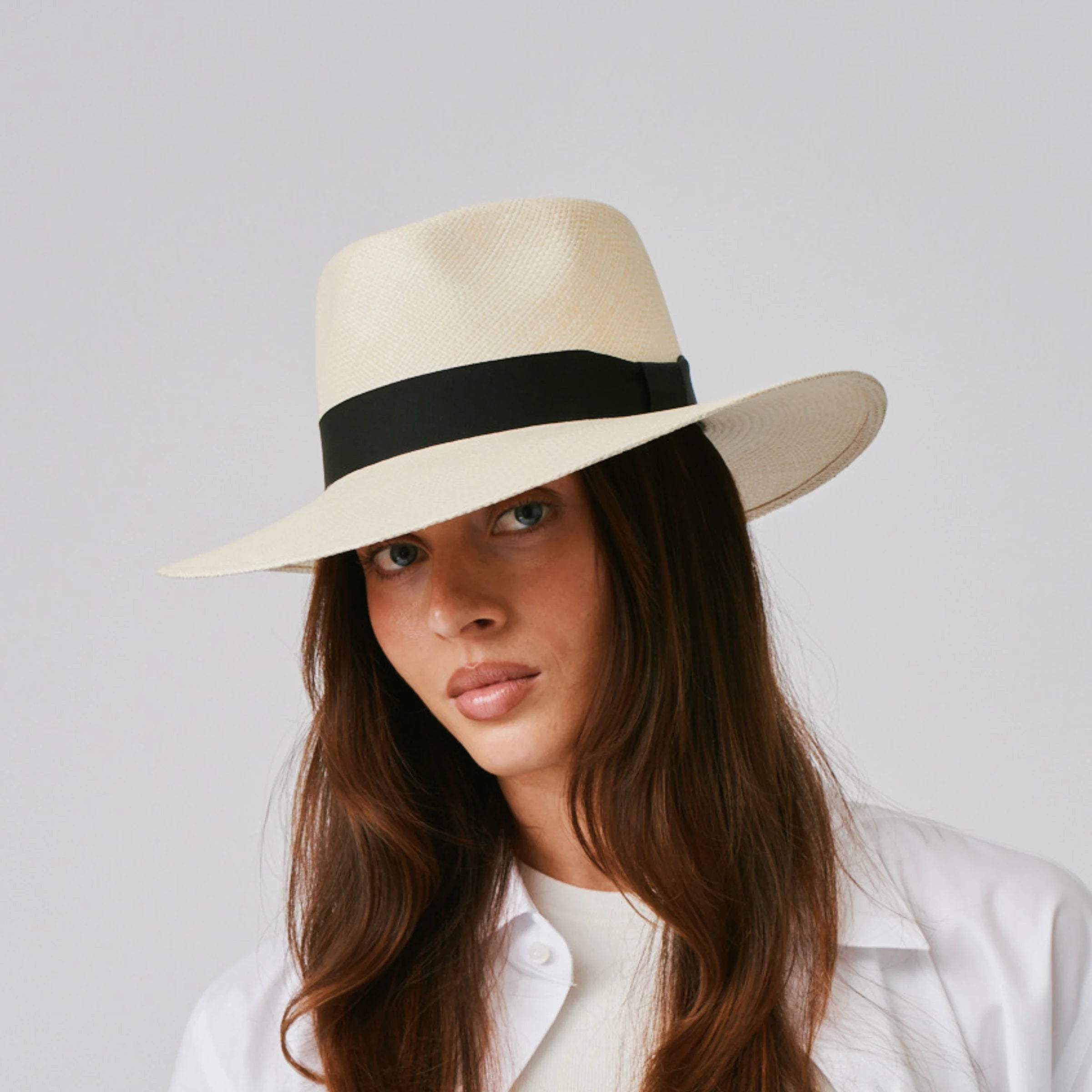 Woman wearing a Country Natural / Black Panama hat against a plain background.