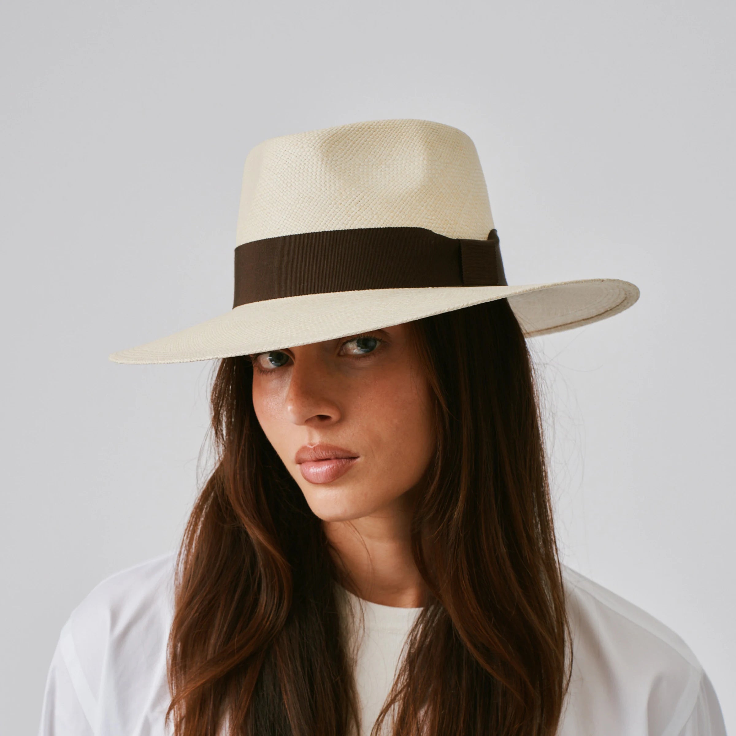 Woman wearing a Country Natural / Chocolate Panama hat against a plain background.