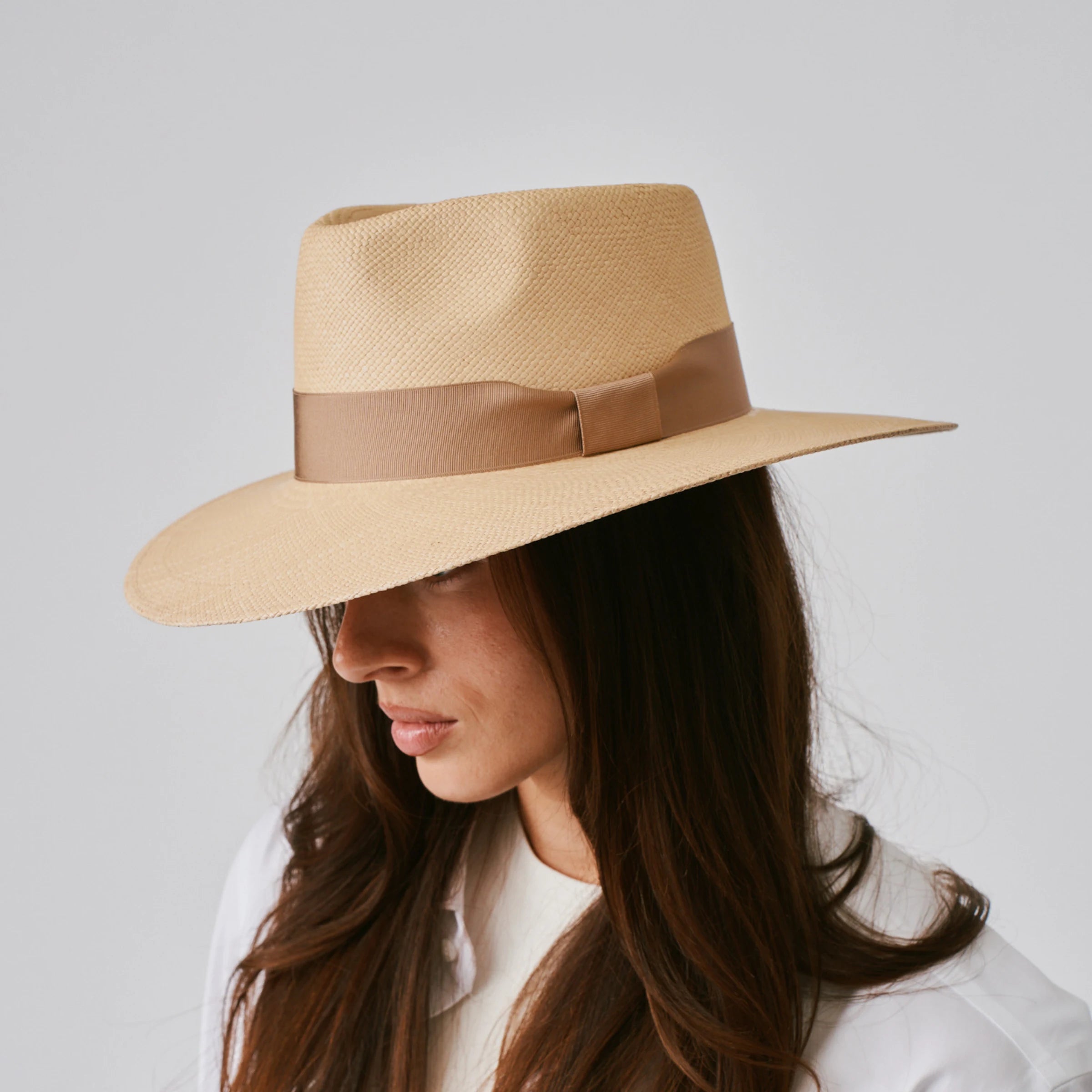 Woman wearing a Country Sand / Tan Panama hat against a plain background.