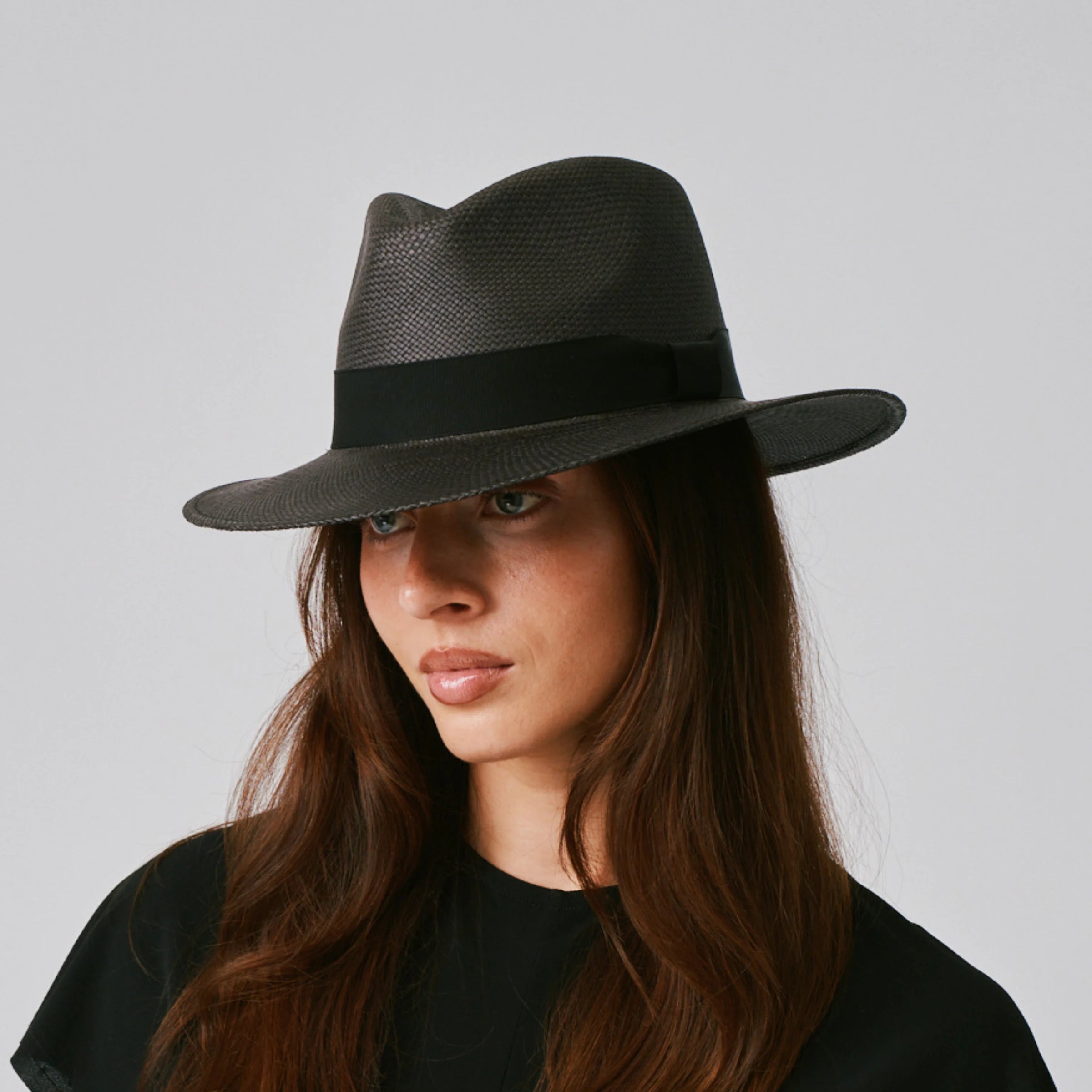 Woman wearing a Executive Black / Black Panama hat against a plain background.