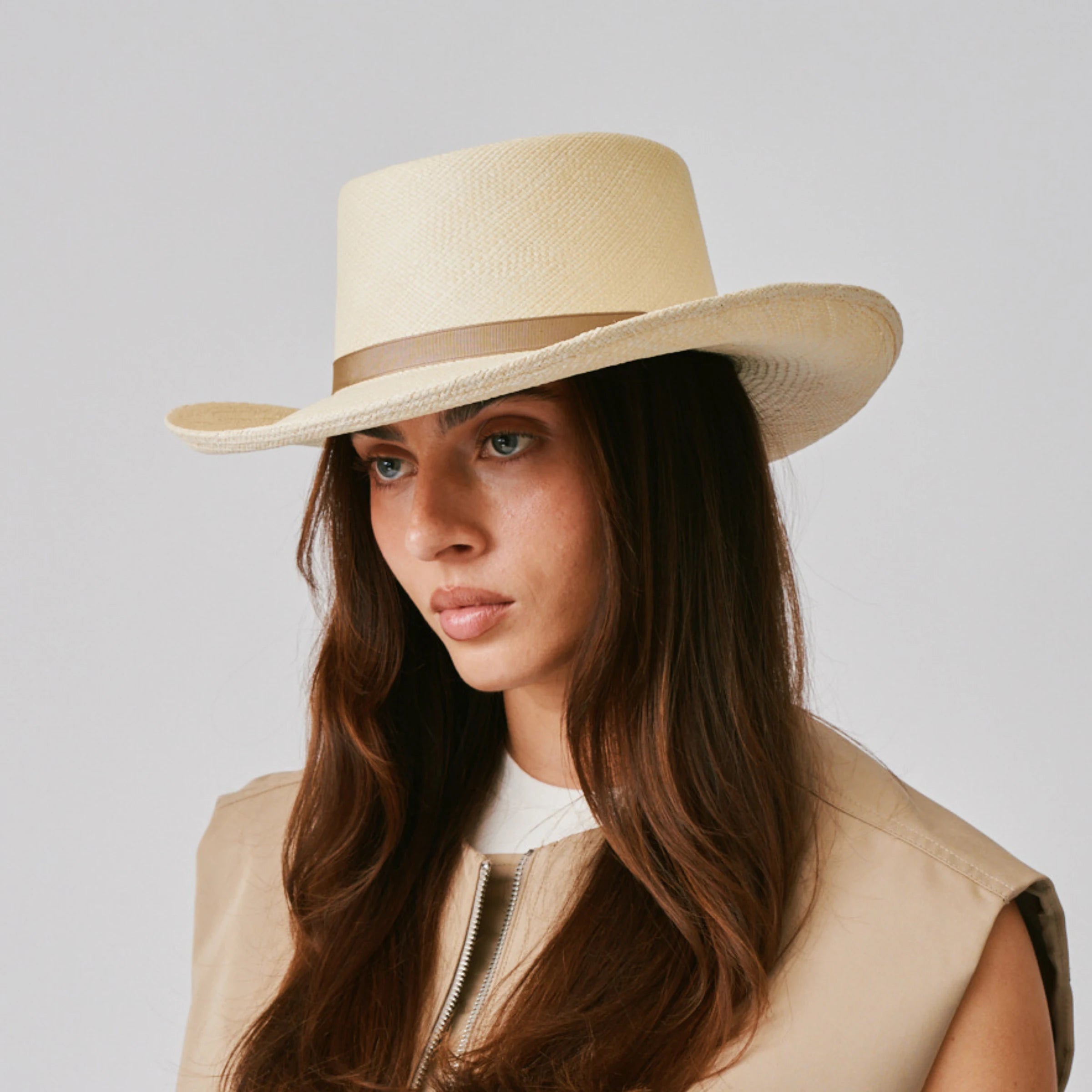 Woman wearing a Gambler Natural / Taupe Panama hat against a plain background.