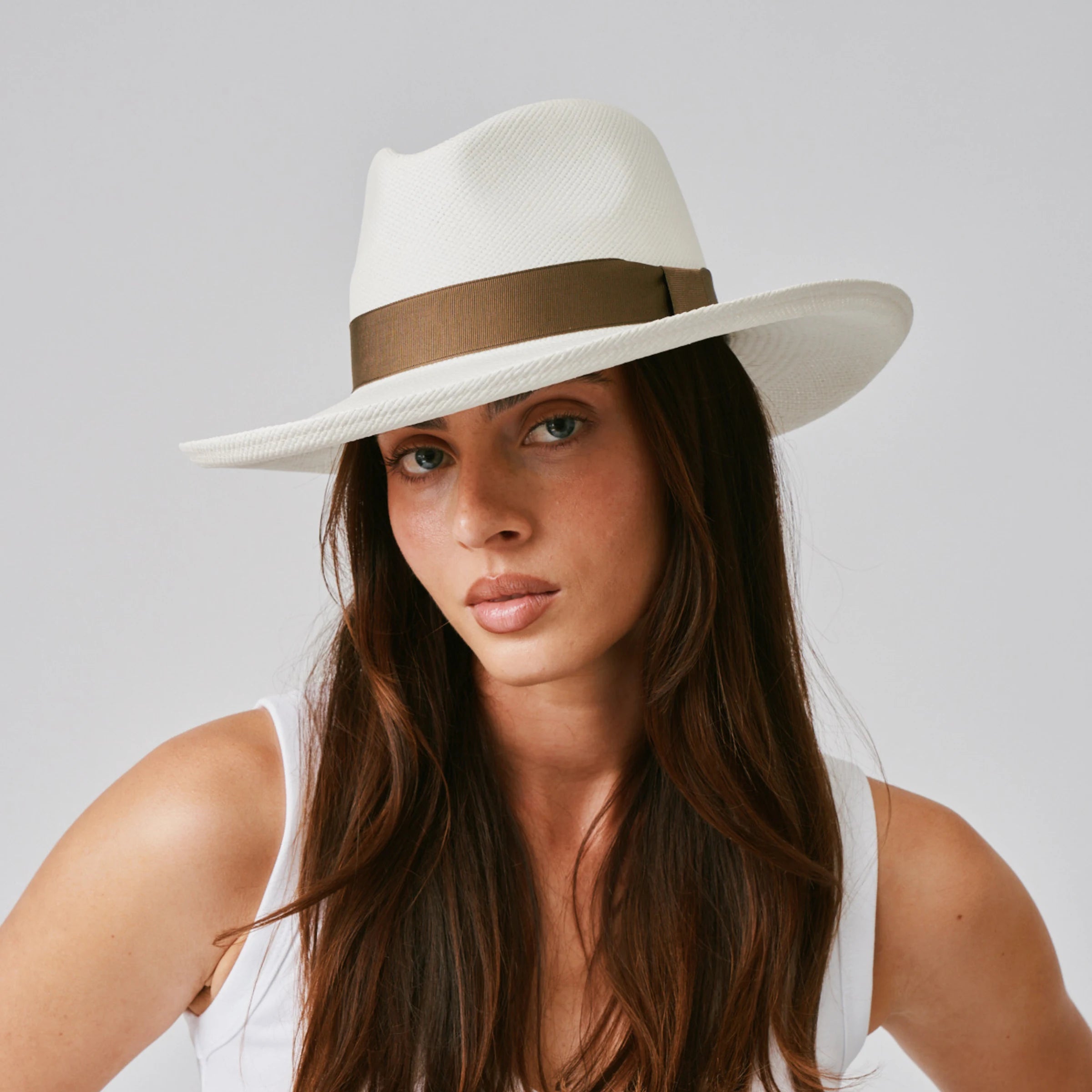 Woman wearing a Grand Planter Cream / Fawn Panama hat against a plain background.