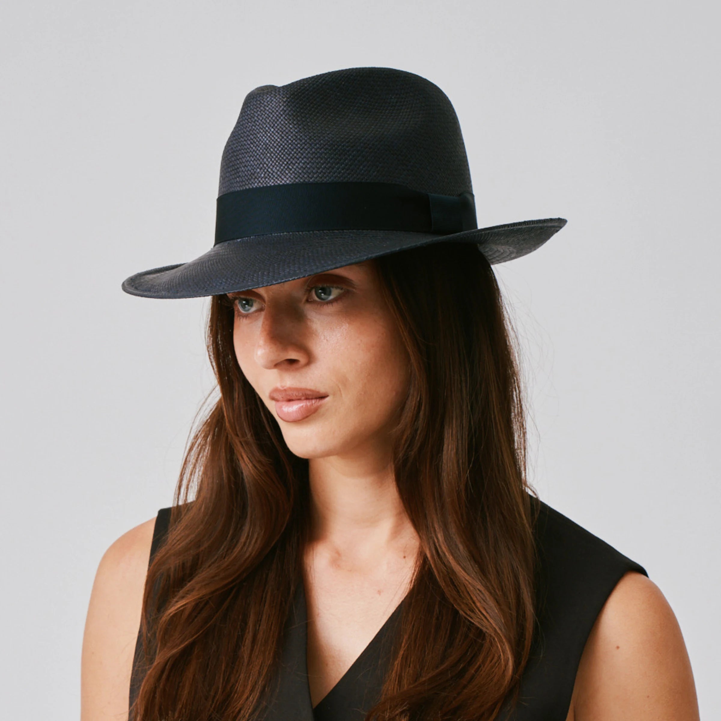 Woman wearing a New Fedora Navy / Marine Panama hat against a plain background.