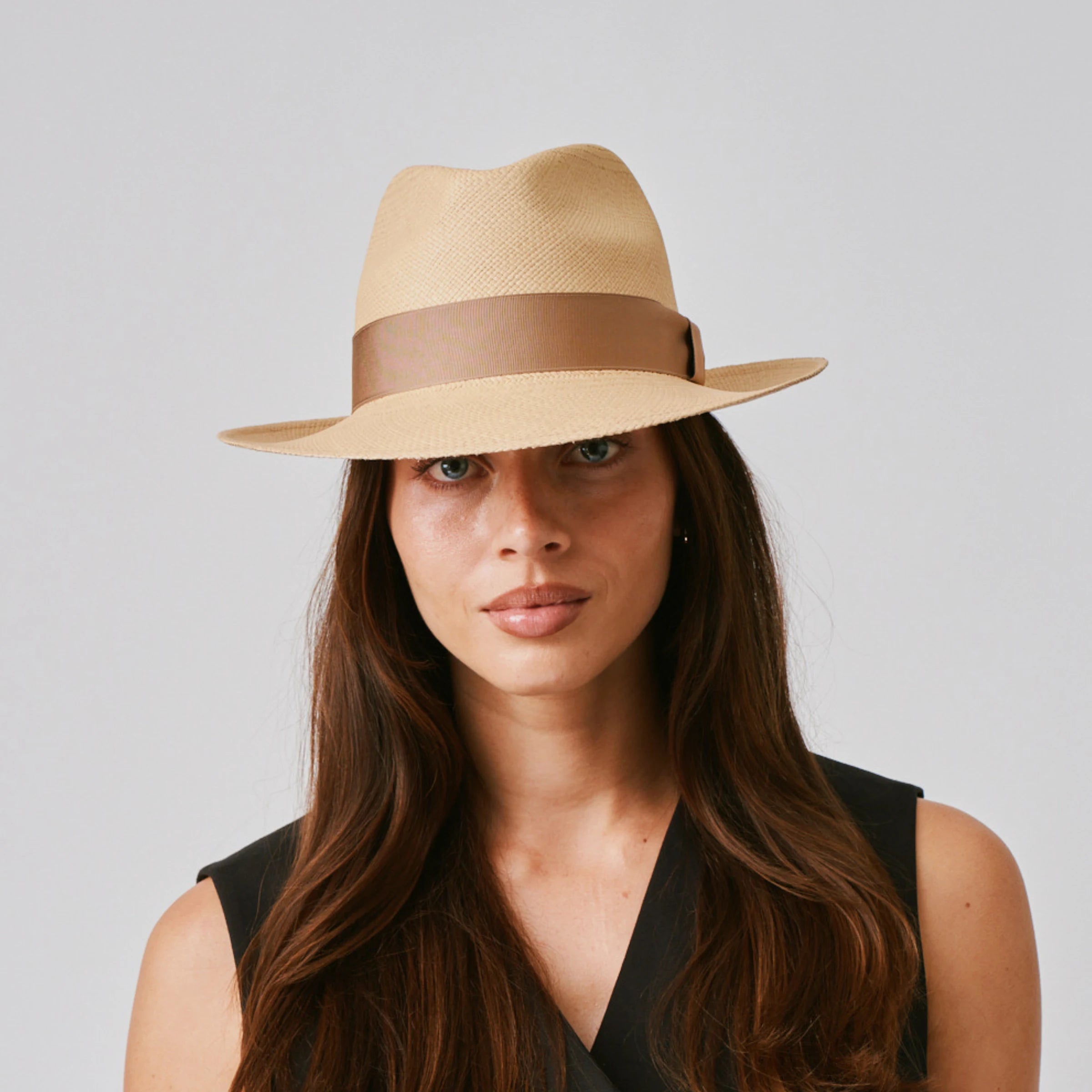 Woman wearing a New Fedora Sand / Tan Panama hat and black top against a plain background.