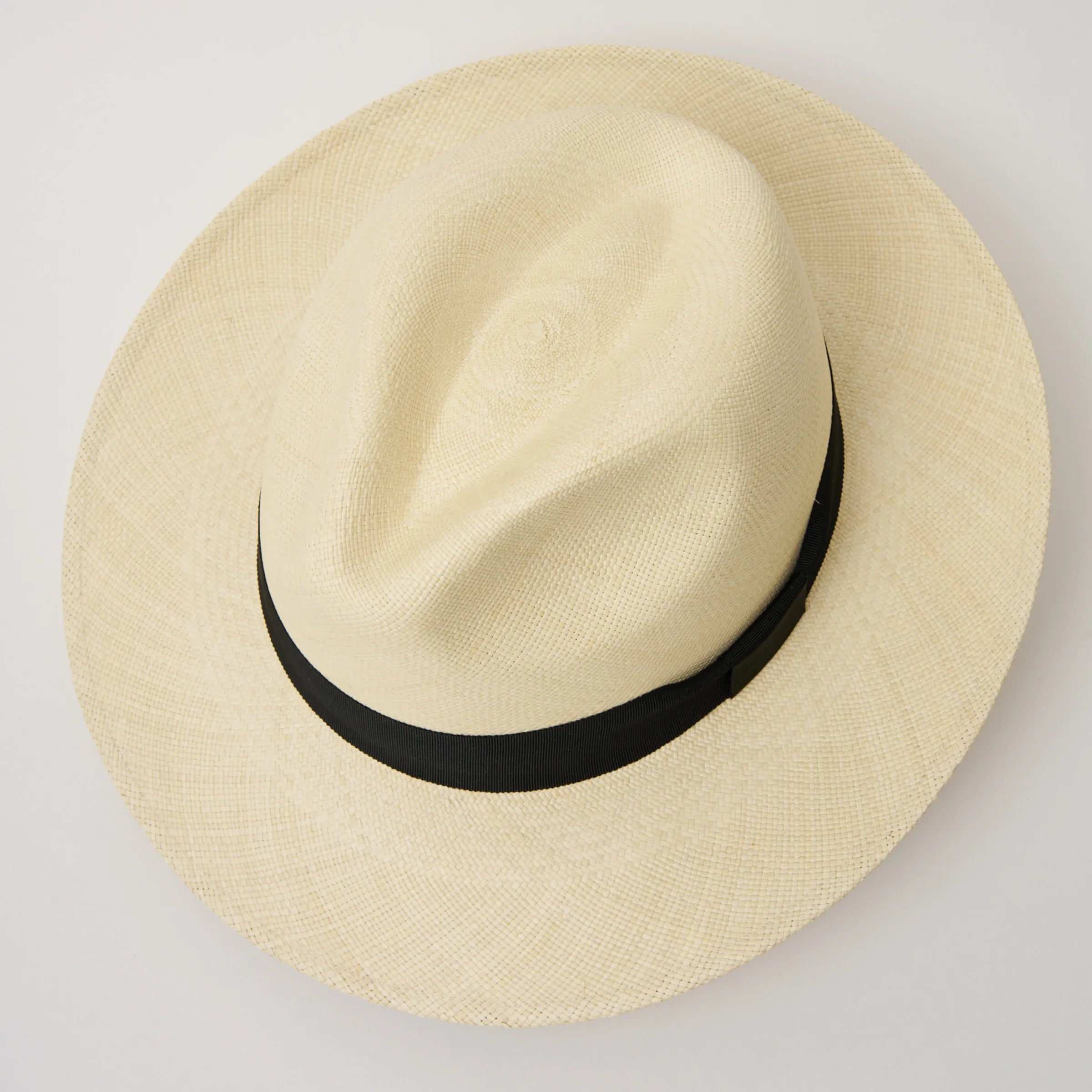 Studio image, looking from top-down at the Camilo Classic Fino Natural coloured Panama Hat with Black trim, showing the crown shape and pinch.