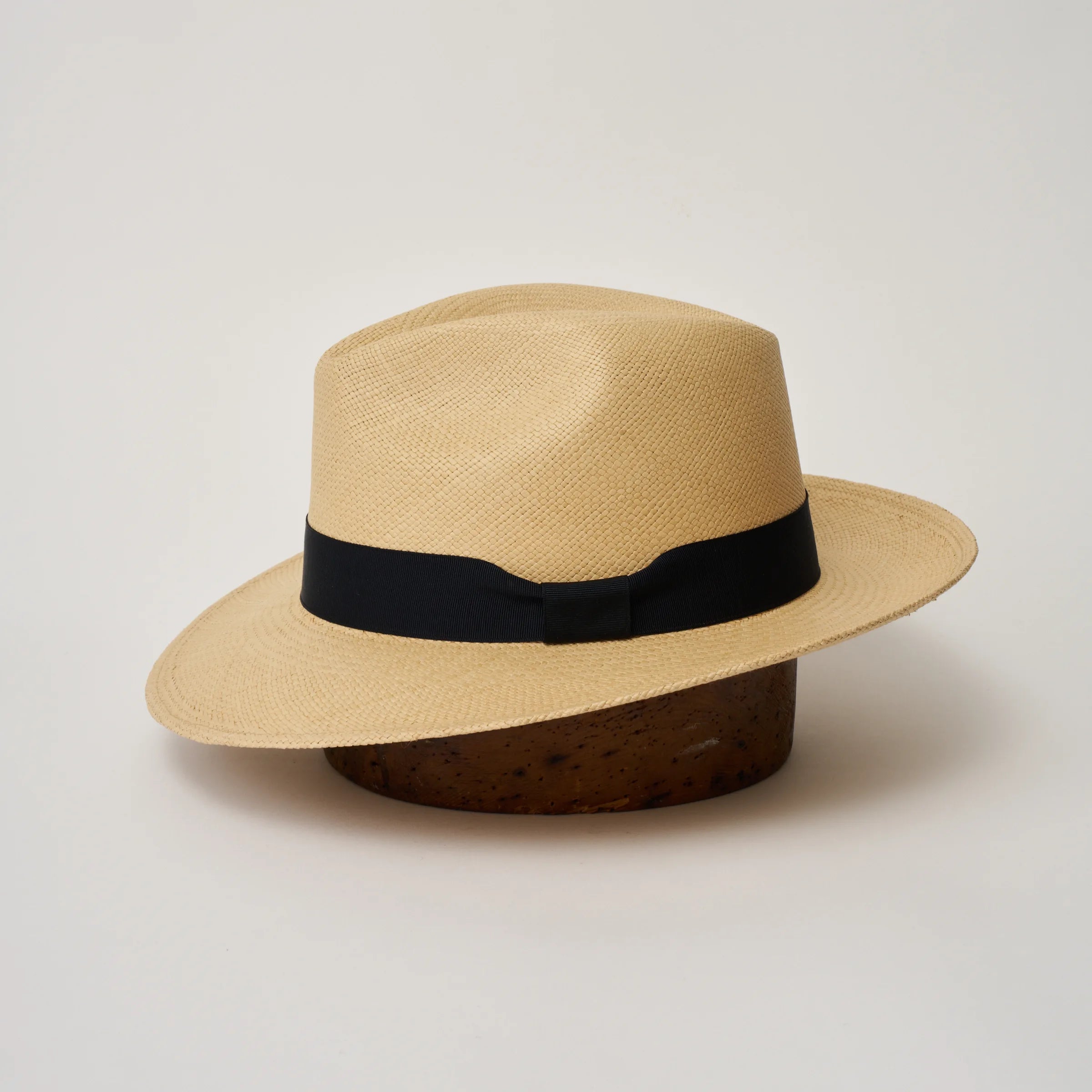 Studio image of the Camilo Classic Sand coloured Panama Hat with Marine trim shown from the side, showing the brim shape and ribbon finish.
