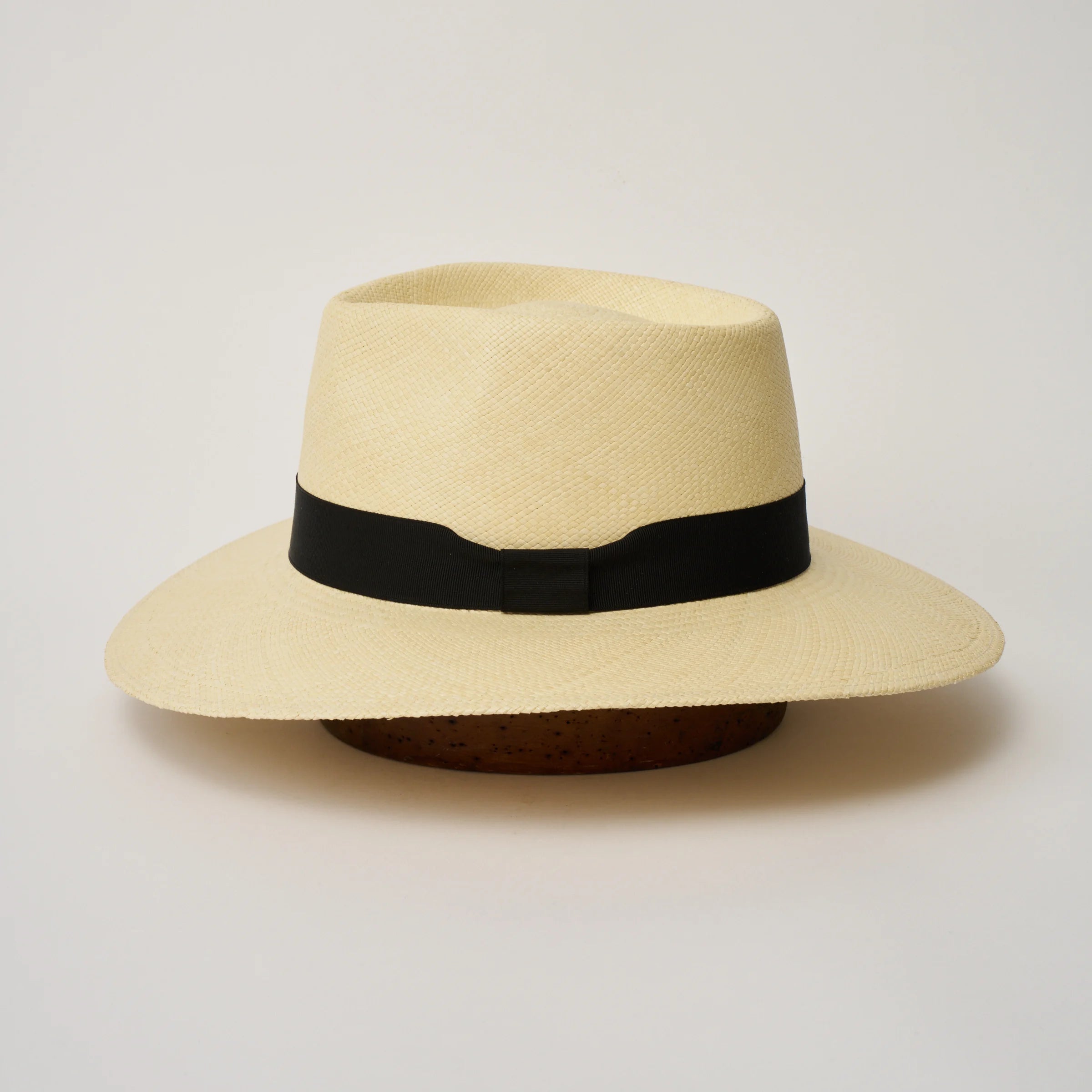 Studio image of the Camilo Country Natural coloured Panama Hat with Black trim shown from the side, showing the brim shape and ribbon finish.
