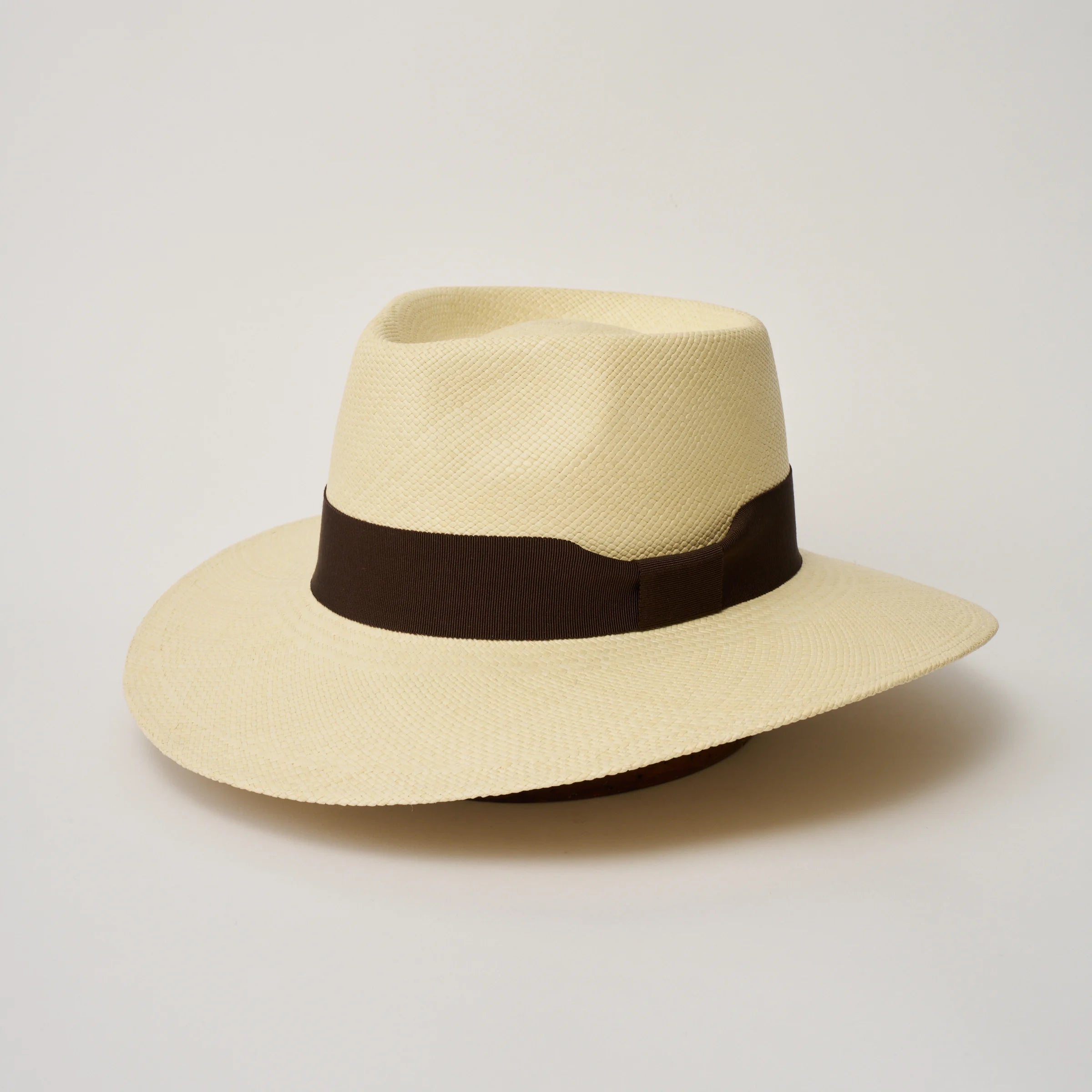 Studio image of the Camilo Country Natural coloured Panama Hat with Chocolate trim, angled showing the crown shape, front crease and ribbon details.